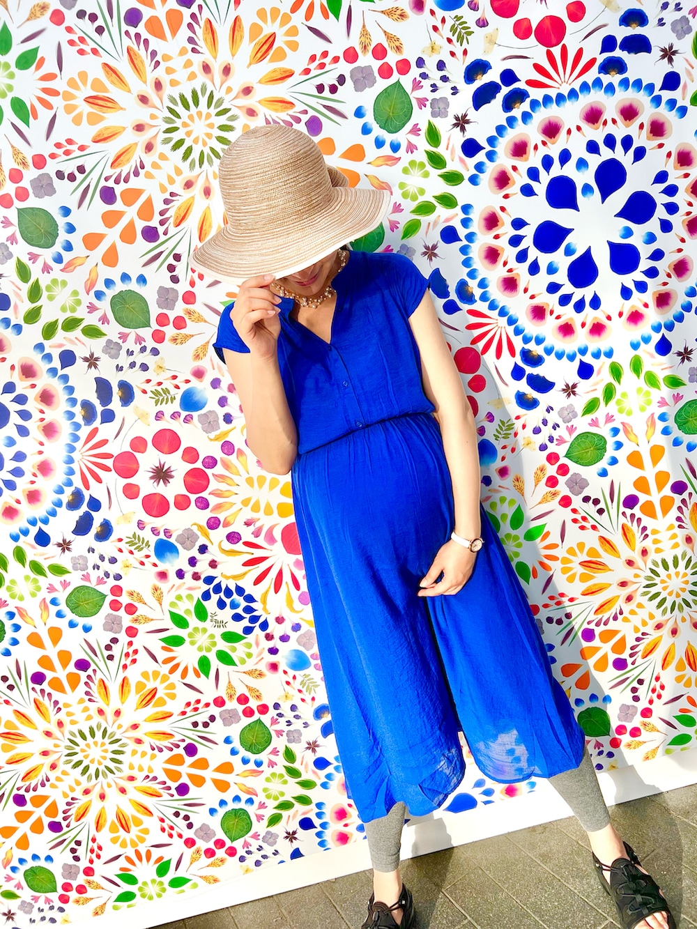 ブルー系のワンピース、ホワイト系のサンダル、ベージュ系のハットを着用したレディースの夏コーディネートの4枚目の写真