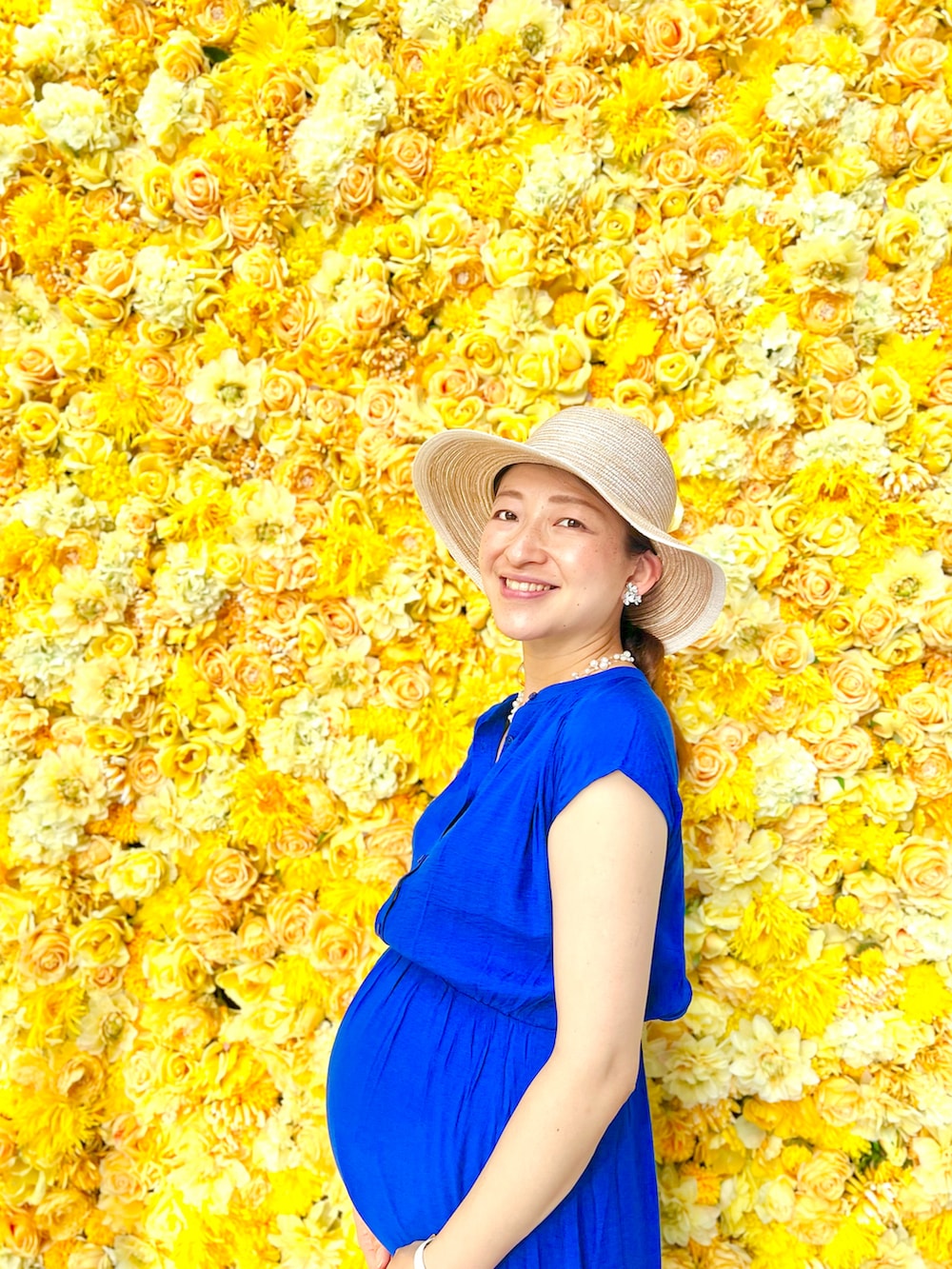 ブルー系のワンピース、ホワイト系のサンダル、ベージュ系のハットを着用したレディースの夏コーディネートの3枚目の写真