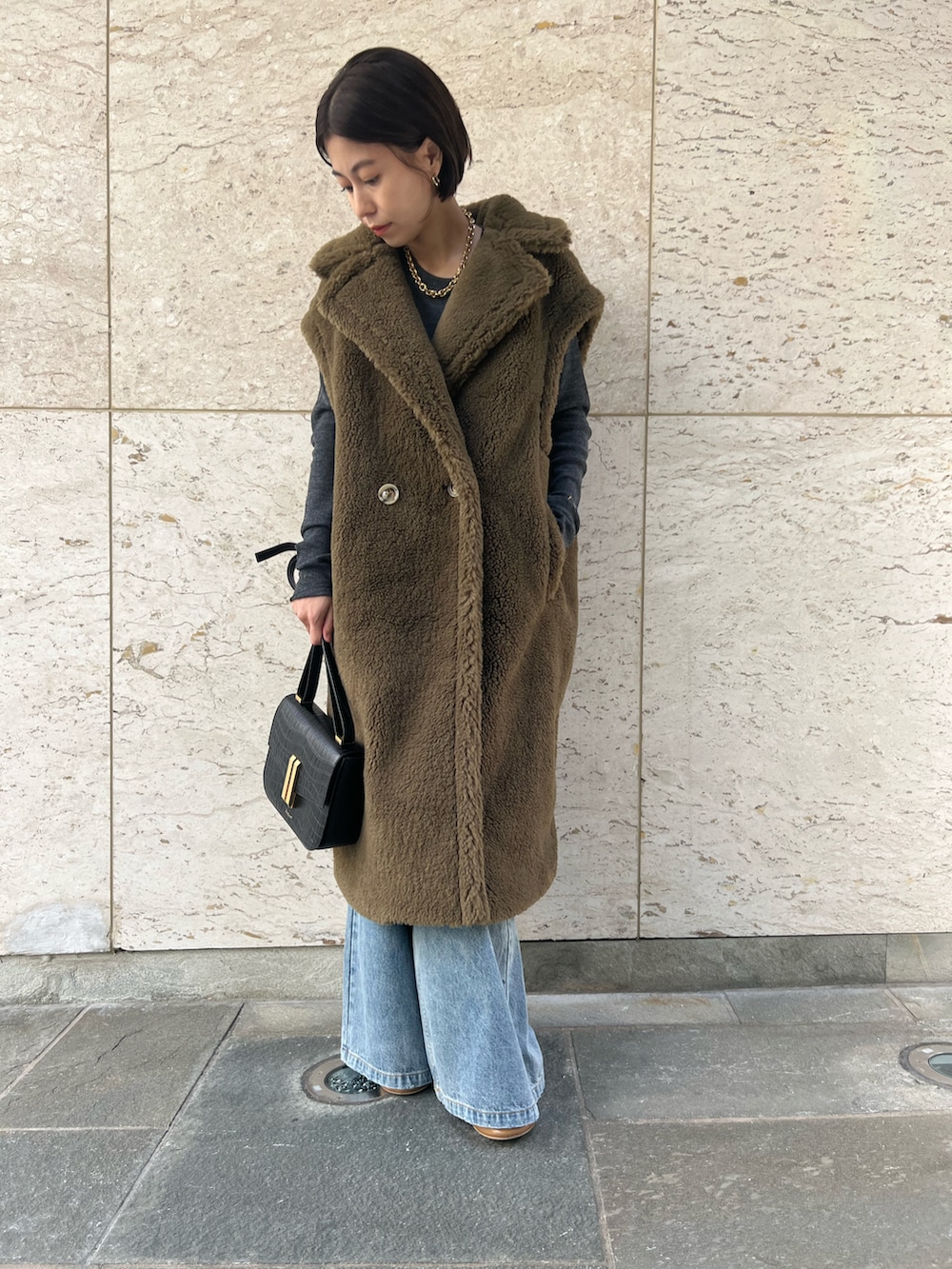 グリーン系のその他アウター、ブルー系のデニムパンツ、グレー系のニット/セーターを着用したレディースの秋コーディネートの2枚目の写真