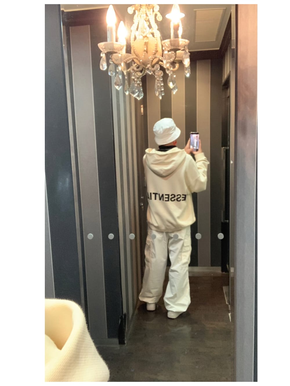 ホワイト系のパーカー、ホワイト系のカーゴパンツ、ホワイト系のスニーカーを着用したメンズの冬コーディネートの2枚目の写真