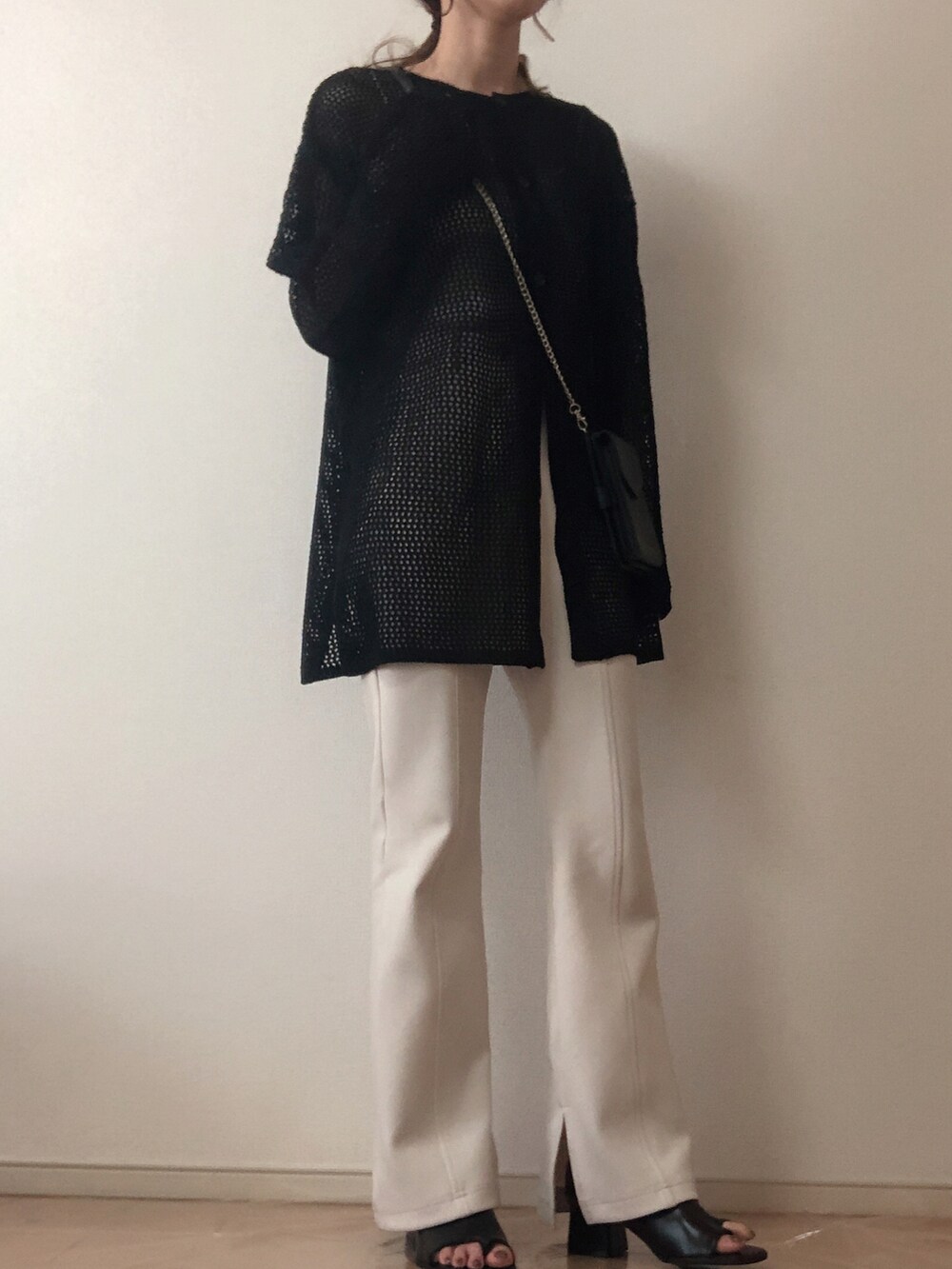 ブラック系のカーディガン/ボレロ、ホワイト系のその他パンツ、ブラック系のブーツを着用したレディースの春コーディネートの2枚目の写真