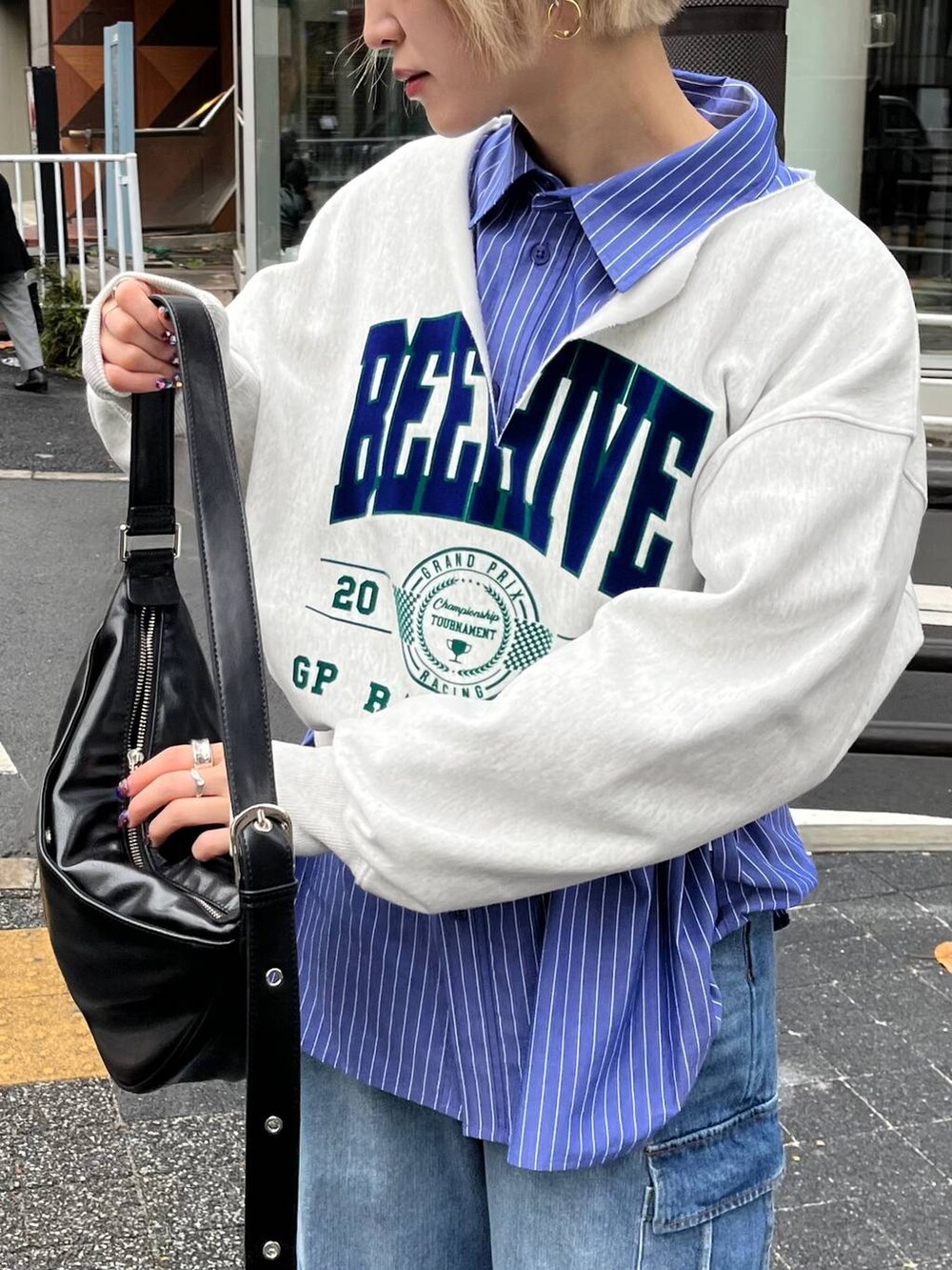 ブルー系のシャツ/ブラウス、ブラック系のショルダーバッグ、ブルー系のデニムパンツを着用したレディースの冬コーディネートの2枚目の写真