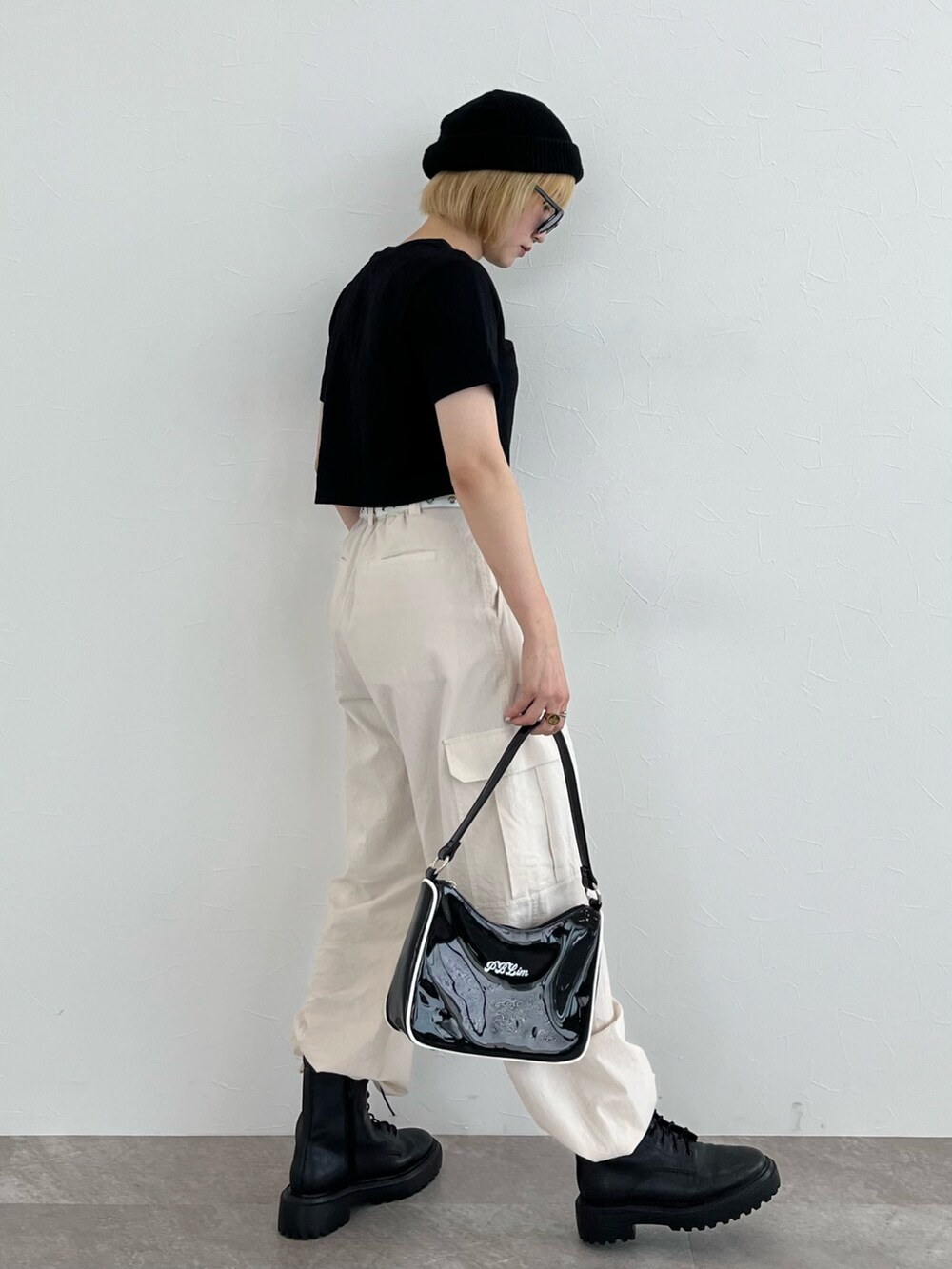 ブラック系のTシャツ/カットソー、ブラック系のハンドバッグ、ホワイト系のパンツを着用したレディースの夏コーディネートの2枚目の写真