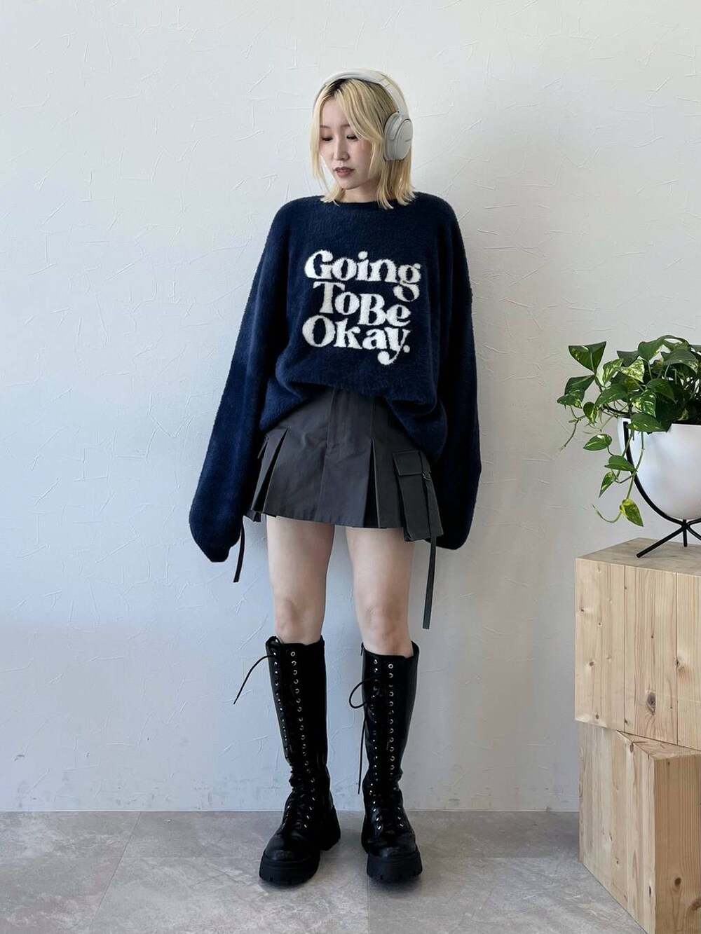 ブラック系のブーツ、ブルー系のニット/セーター、グレー系のスカートを着用したレディースの秋コーディネートの3枚目の写真