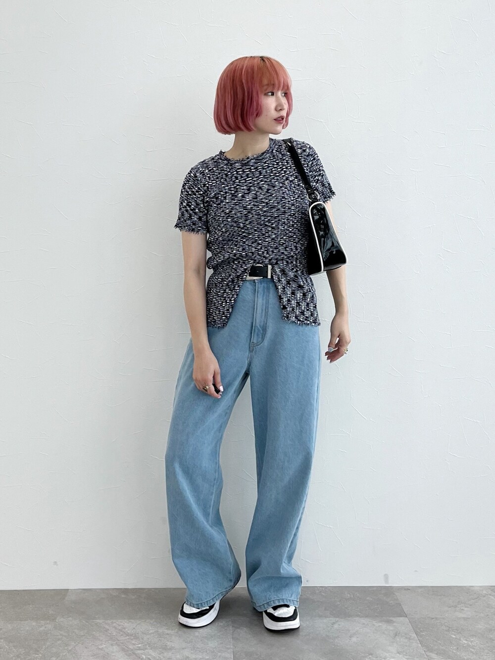 ブルー系のデニムパンツ、ブルー系のニット/セーター、ブラック系のショルダーバッグを着用したレディースの夏コーディネートの2枚目の写真