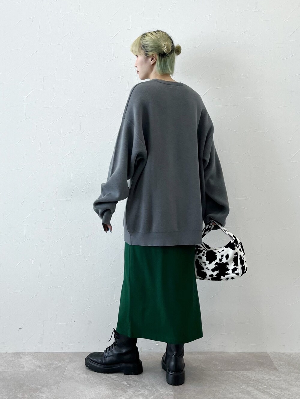 グレー系のニット/セーター、ブラック系のハンドバッグ、グリーン系のスカートを着用したレディースの秋コーディネートの4枚目の写真
