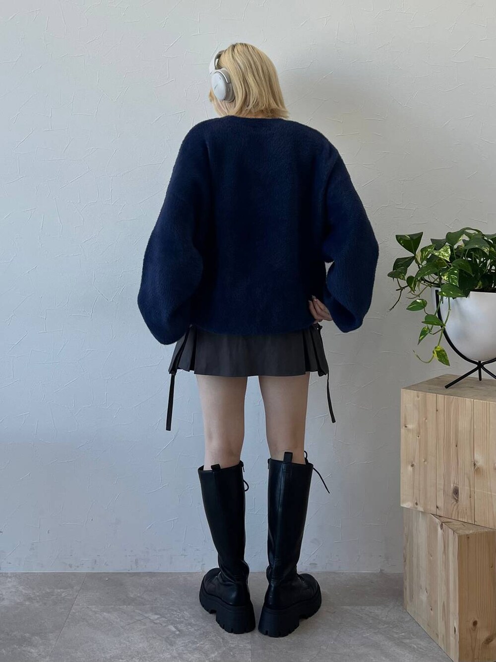 ブラック系のブーツ、ブルー系のニット/セーター、グレー系のスカートを着用したレディースの秋コーディネートの2枚目の写真