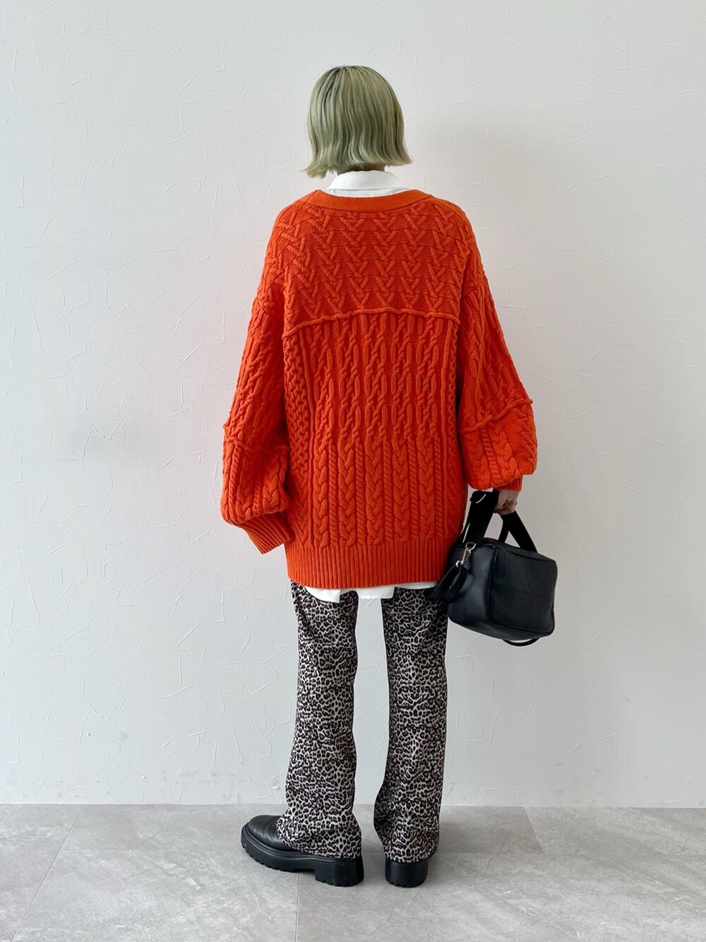 オレンジ系のカーディガン/ボレロ、ホワイト系のシャツ/ブラウス、ブラック系のショルダーバッグを着用したレディースの秋コーディネートの3枚目の写真