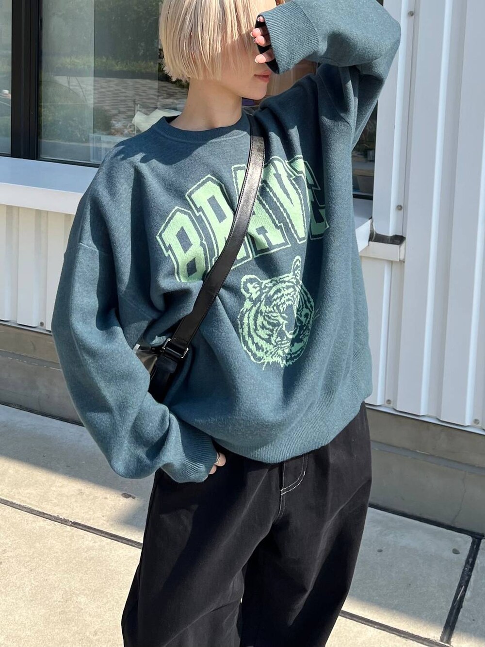 ブラック系のその他パンツ、ブラック系のショルダーバッグ、グリーン系のニット/セーターを着用したレディースの秋コーディネートの3枚目の写真