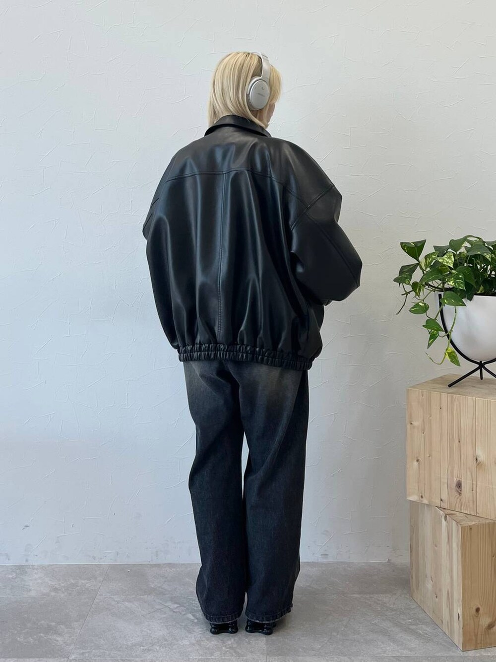 レッド系のニット/セーター、ブラック系のデニムパンツ、ブラック系のブルゾンを着用したレディースの秋コーディネートの2枚目の写真