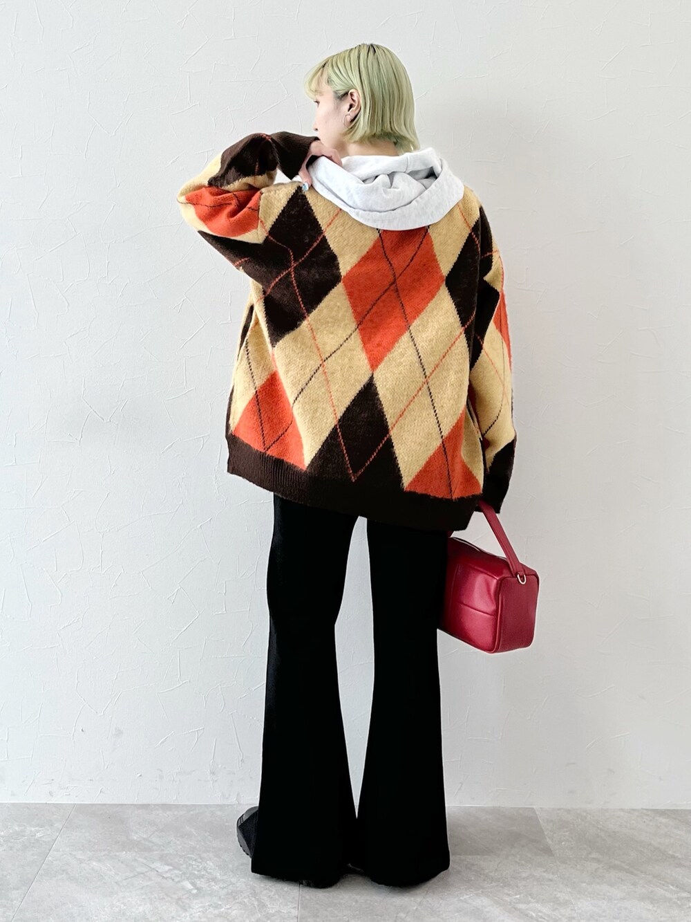 ブラウン系のカーディガン/ボレロ、グレー系のパーカー、レッド系のショルダーバッグを着用したレディースの秋コーディネートの3枚目の写真