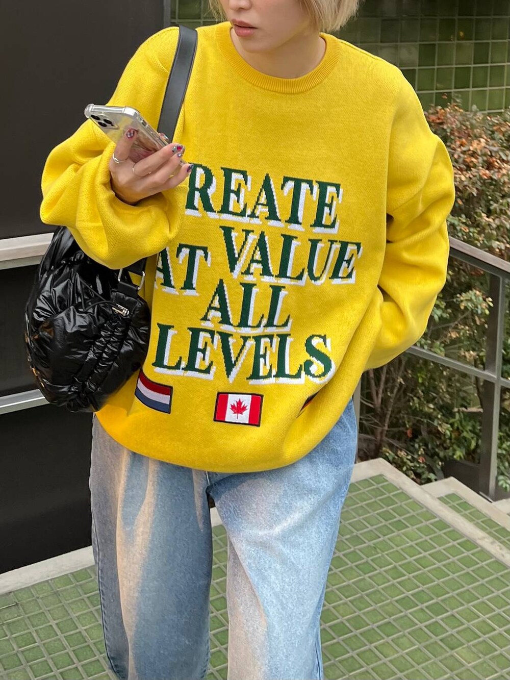 ブラック系のショルダーバッグ、ブルー系のニット/セーターを着用したレディースの冬コーディネートの2枚目の写真