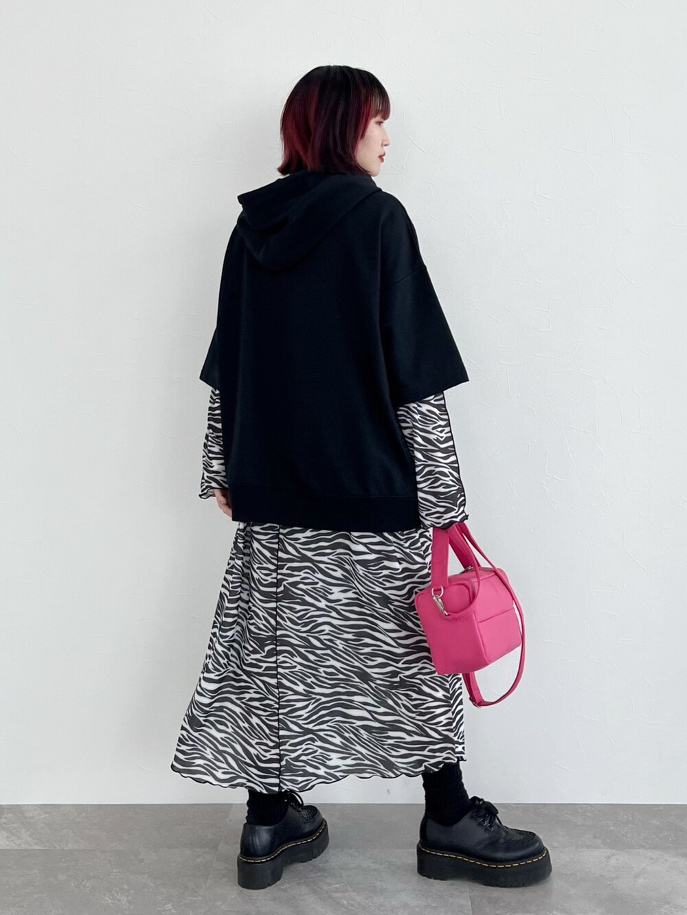 ブラック系のパーカー、その他のワンピース、ピンク系のショルダーバッグを着用したレディースの春コーディネートの3枚目の写真
