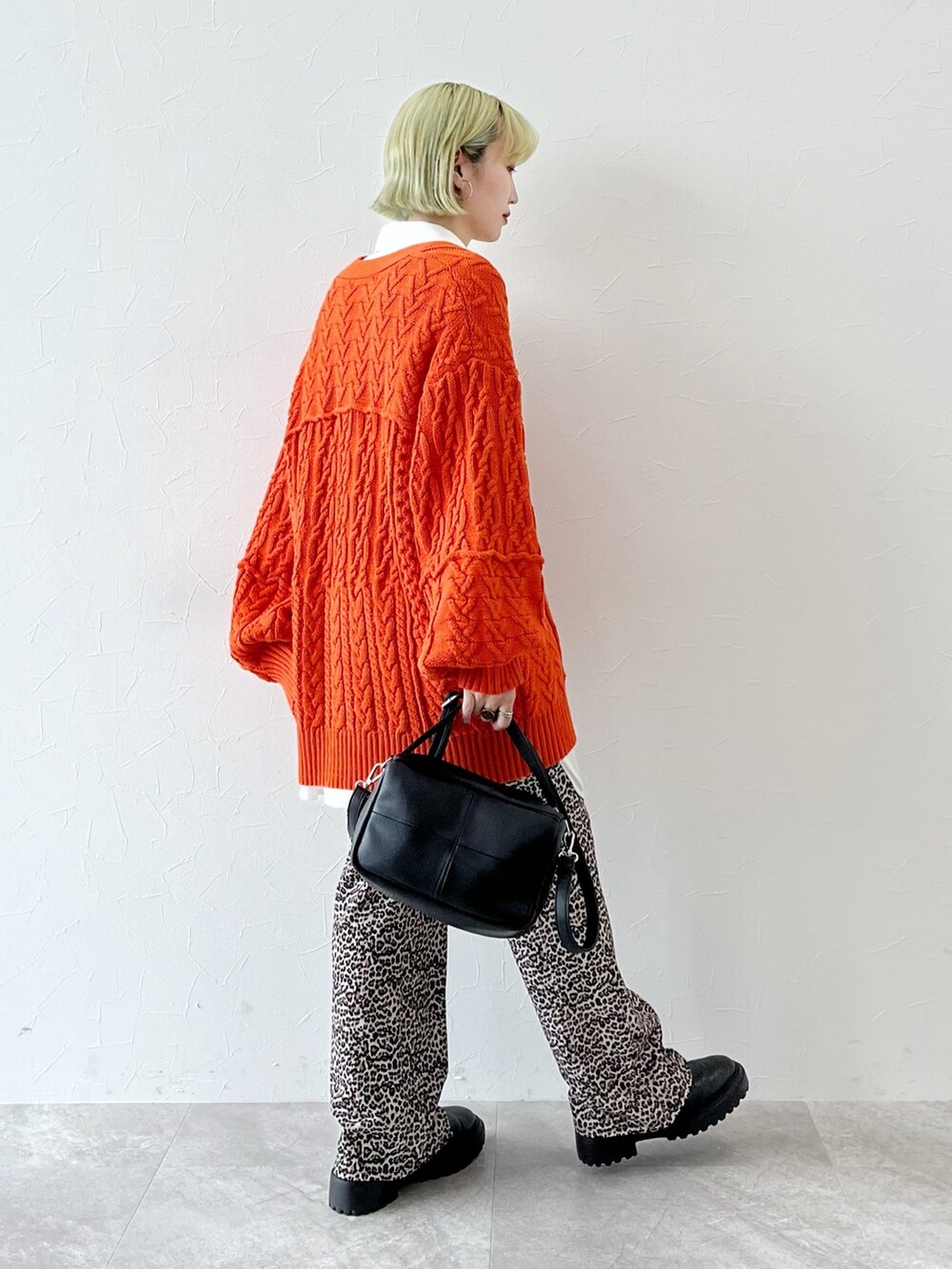 オレンジ系のカーディガン/ボレロ、ホワイト系のシャツ/ブラウス、ブラック系のショルダーバッグを着用したレディースの秋コーディネートの2枚目の写真