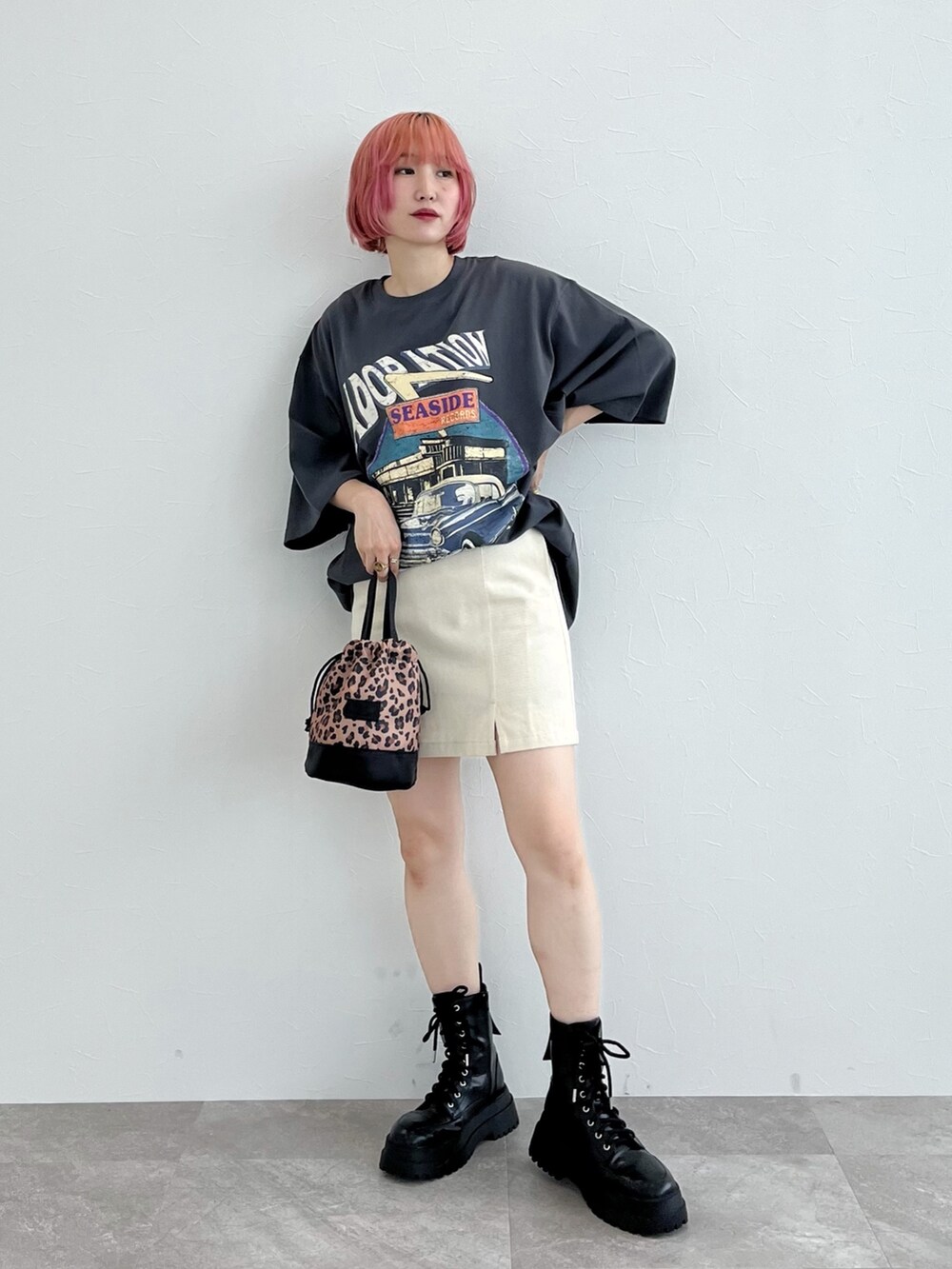 グレー系のTシャツ/カットソー、ホワイト系のスカート、ブラック系のブーツを着用したレディースの夏コーディネートの3枚目の写真