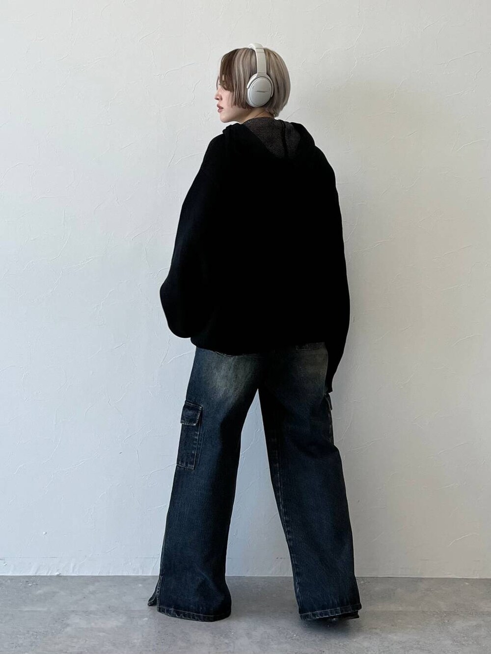 ブラック系のニット/セーター、ブルー系のデニムパンツを着用したレディースの秋コーディネートの2枚目の写真