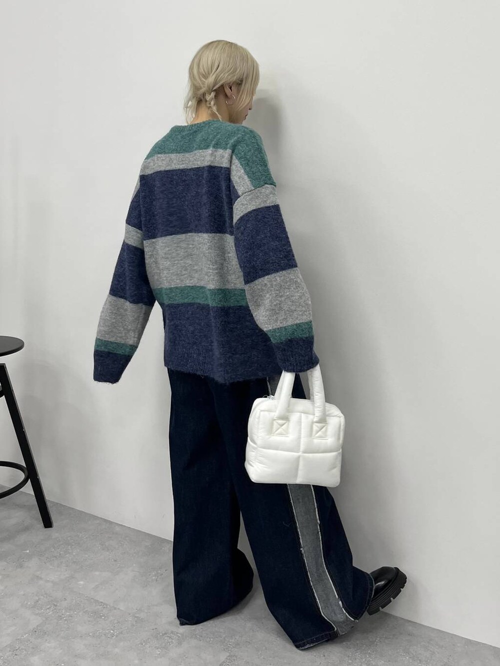 ブルー系のデニムパンツ、ブラック系のその他シューズ、ホワイト系のハンドバッグを着用したレディースの秋コーディネートの2枚目の写真