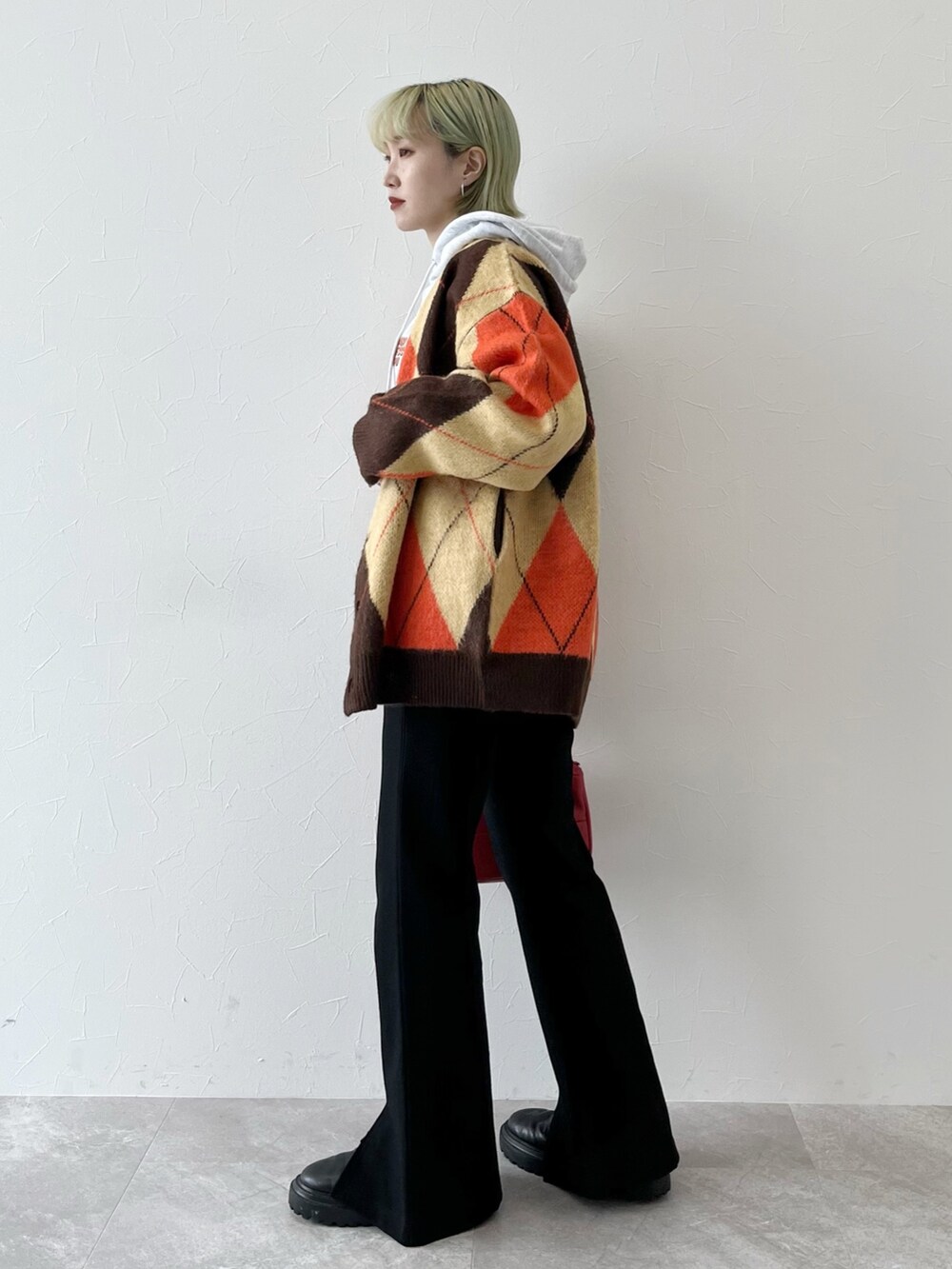 ブラウン系のカーディガン/ボレロ、グレー系のパーカー、レッド系のショルダーバッグを着用したレディースの秋コーディネートの2枚目の写真