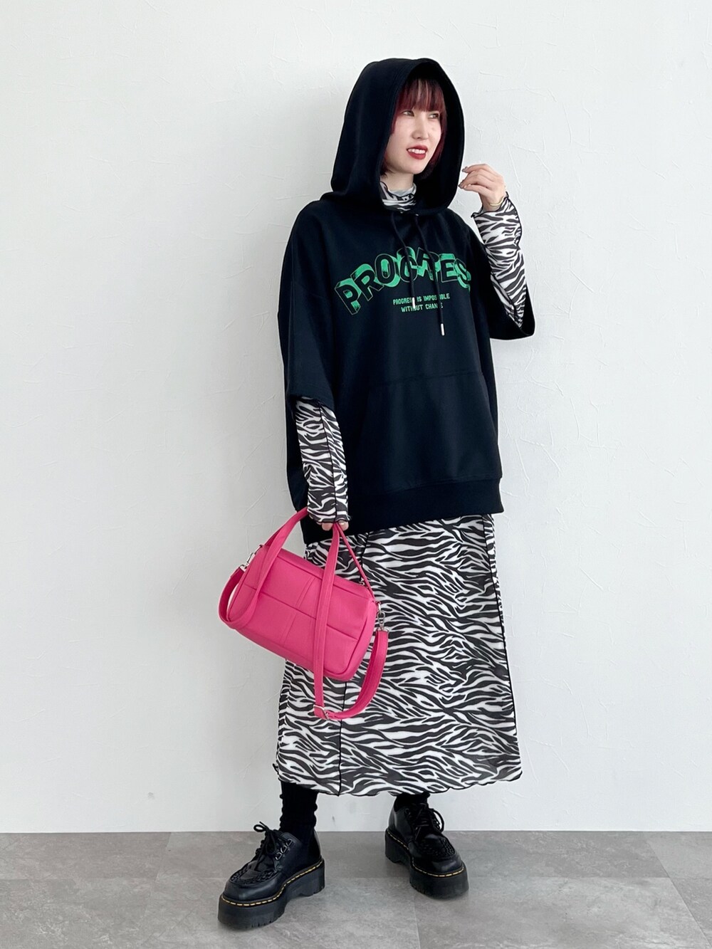 ブラック系のパーカー、その他のワンピース、ピンク系のショルダーバッグを着用したレディースの春コーディネートの4枚目の写真