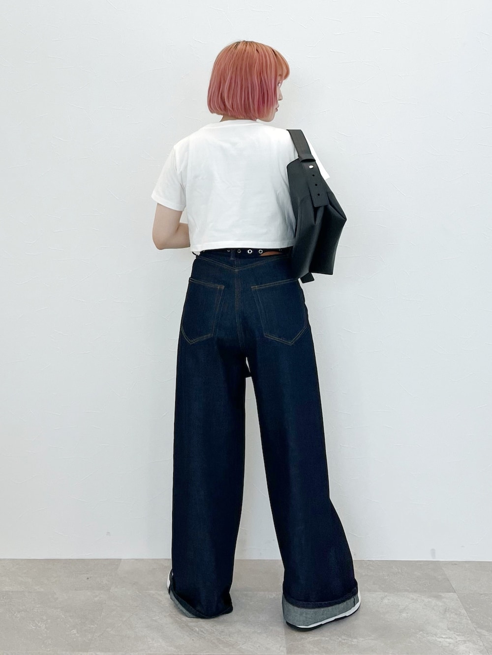 ブルー系のデニムパンツ、ホワイト系のTシャツ/カットソー、ブラック系のベルトを着用したレディースの夏コーディネートの2枚目の写真