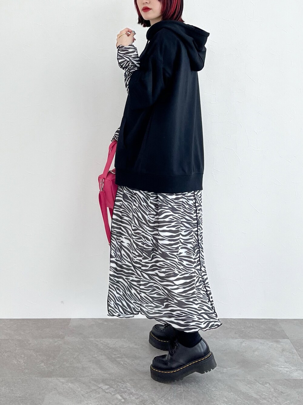 ブラック系のパーカー、その他のワンピース、ピンク系のショルダーバッグを着用したレディースの春コーディネートの2枚目の写真