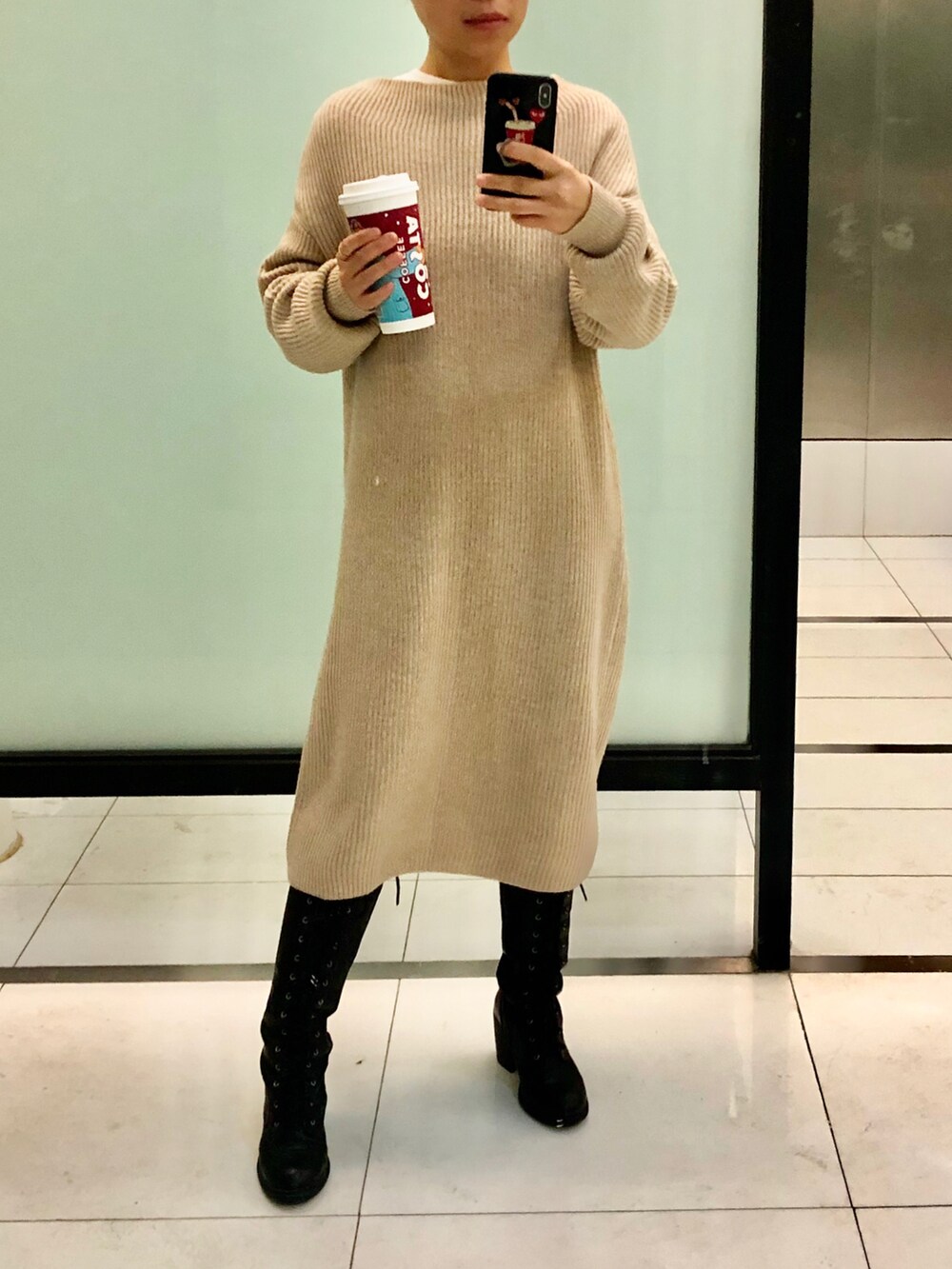 グレー系のダウンジャケット/コート、ベージュ系のワンピース、ブラウン系のショルダーバッグを着用したレディースの冬コーディネートの2枚目の写真