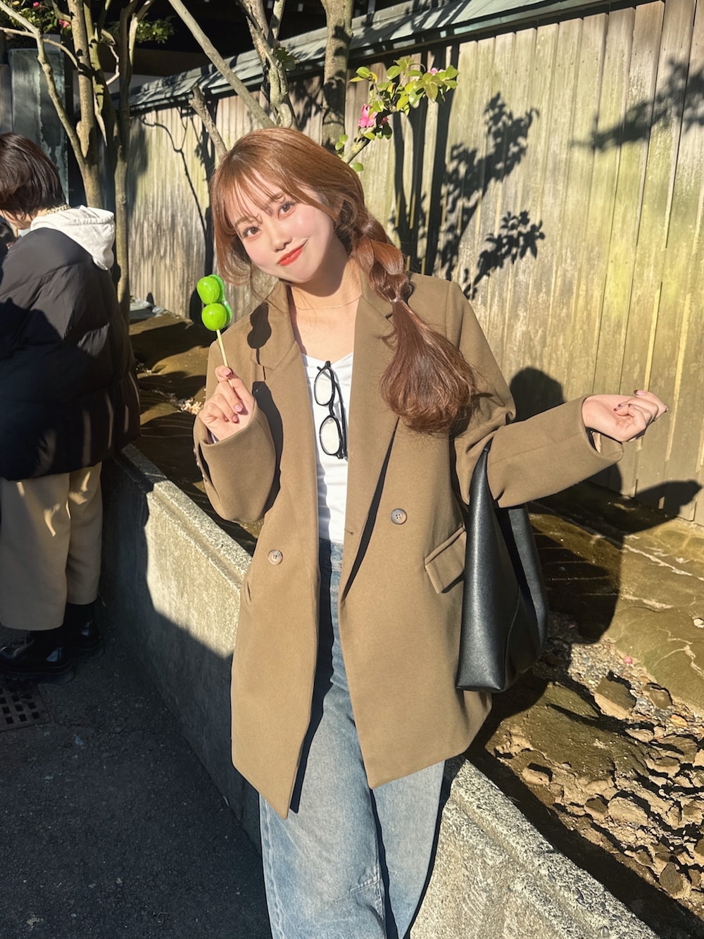 ブルー系のパンツ、ブラック系のハンドバッグを着用したレディースの冬コーディネートの2枚目の写真