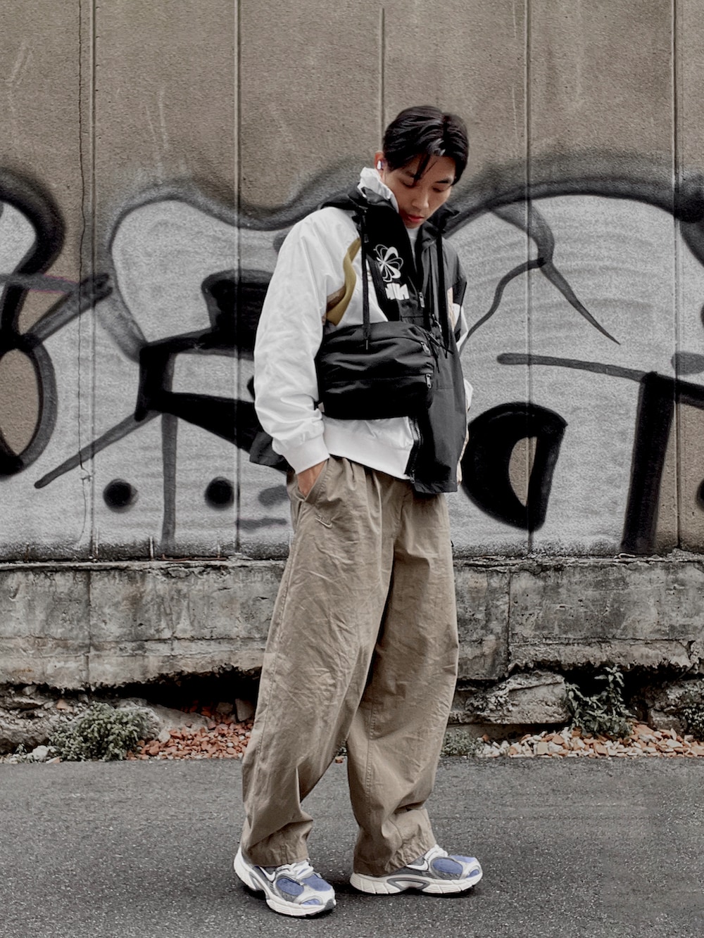 ベージュ系のチノパンツ、ベージュ系のその他アウター、ブラック系のショルダーバッグを着用したメンズの春コーディネートの2枚目の写真