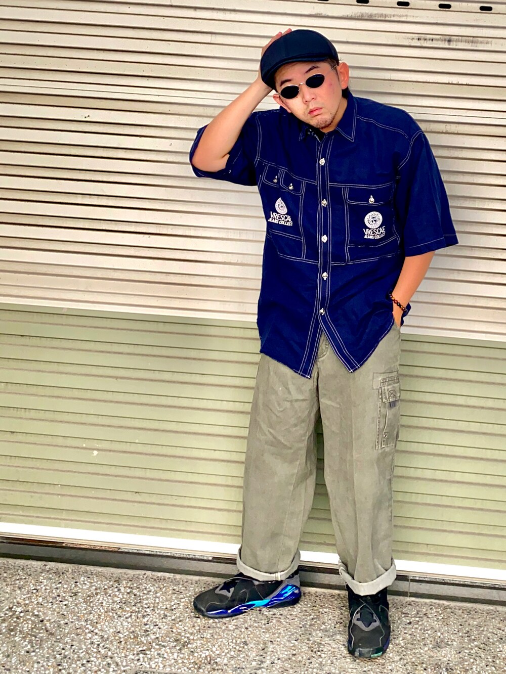 ブラック系のスニーカー、グリーン系のチノパンツ、ブラック系のその他を着用したメンズの秋コーディネートの2枚目の写真