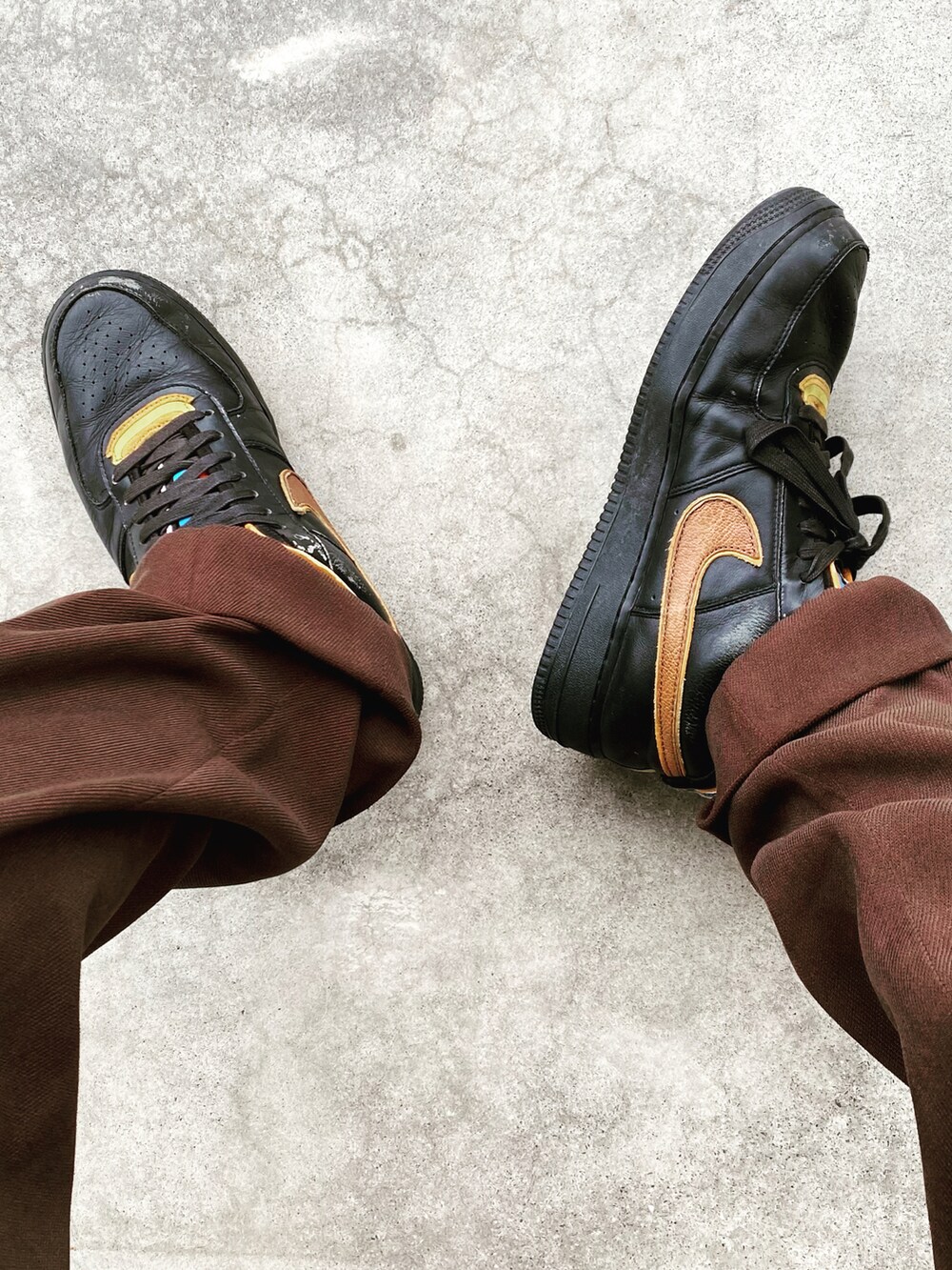 オレンジ系のピーコート、ブラウン系のスラックス、ブラック系のスニーカーを着用したメンズの冬コーディネートの2枚目の写真