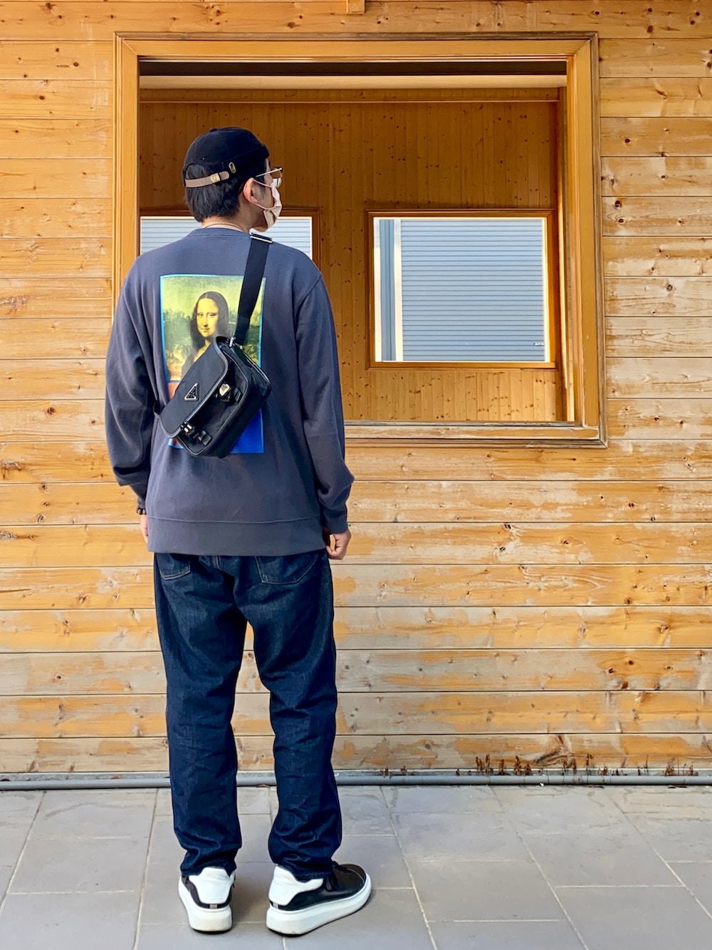 ブルー系のデニムパンツ、グレー系のTシャツ/カットソー、ブラック系のボディバッグ/ウエストポーチを着用したメンズの秋コーディネートの2枚目の写真