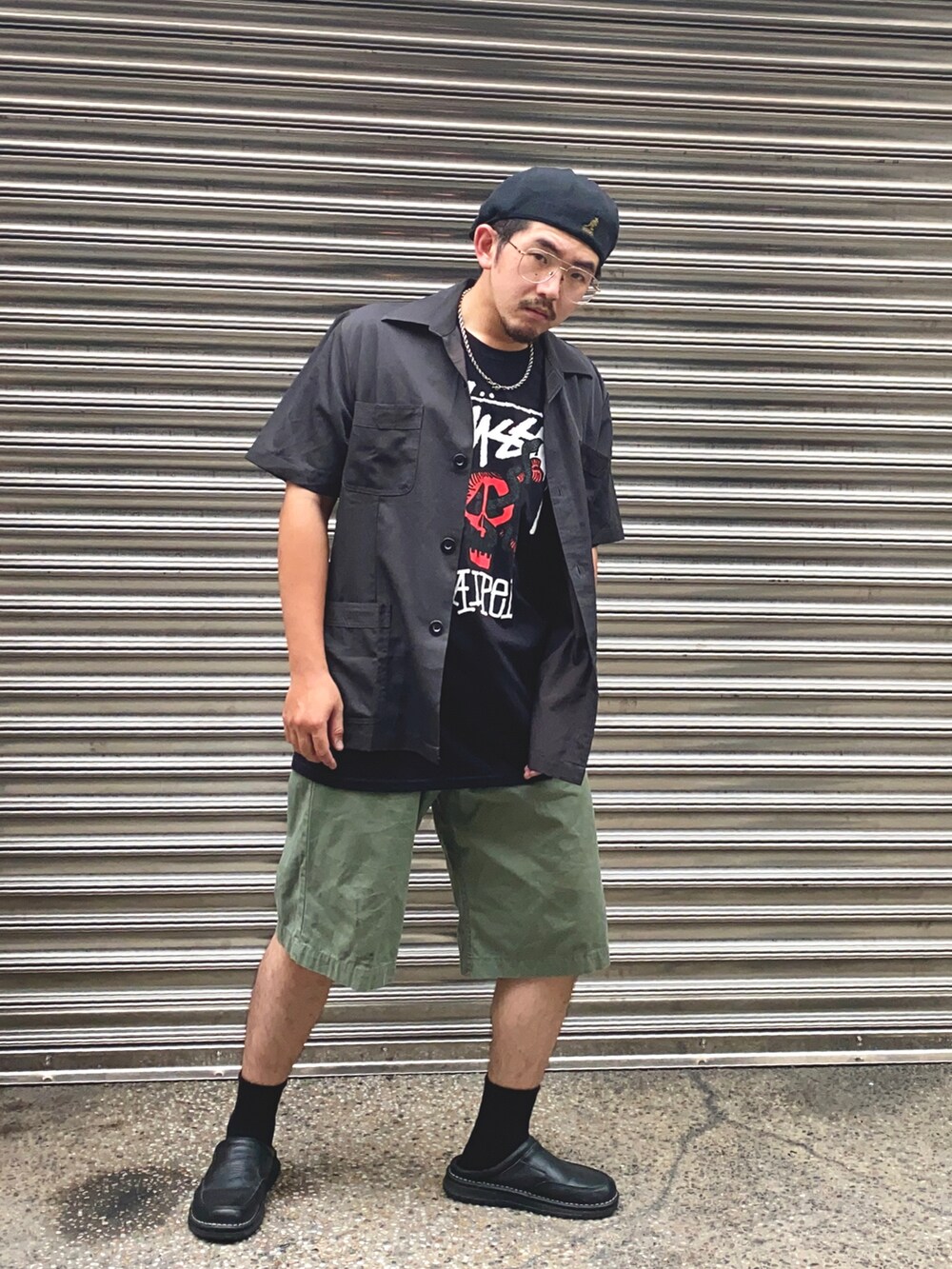 ブラック系のTシャツ/カットソー、グリーン系のカーゴパンツ、ブラック系のハンチング/ベレー帽を着用したメンズの秋コーディネートの2枚目の写真