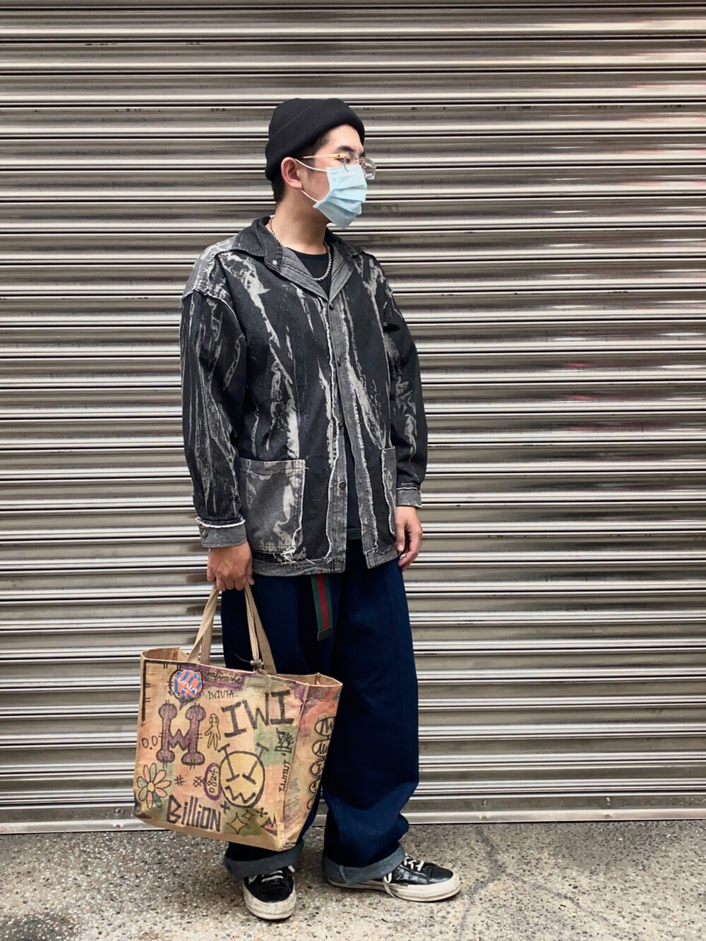 ブラック系のスニーカー、ブルー系のデニムパンツを着用したメンズの冬コーディネートの2枚目の写真