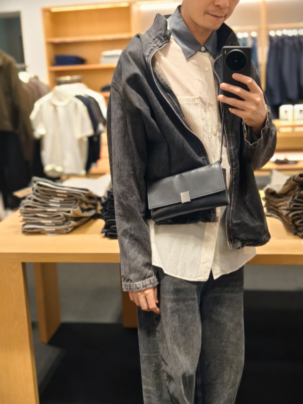 ブラック系のデニムジャケットを着用したメンズの秋コーディネートの2枚目の写真