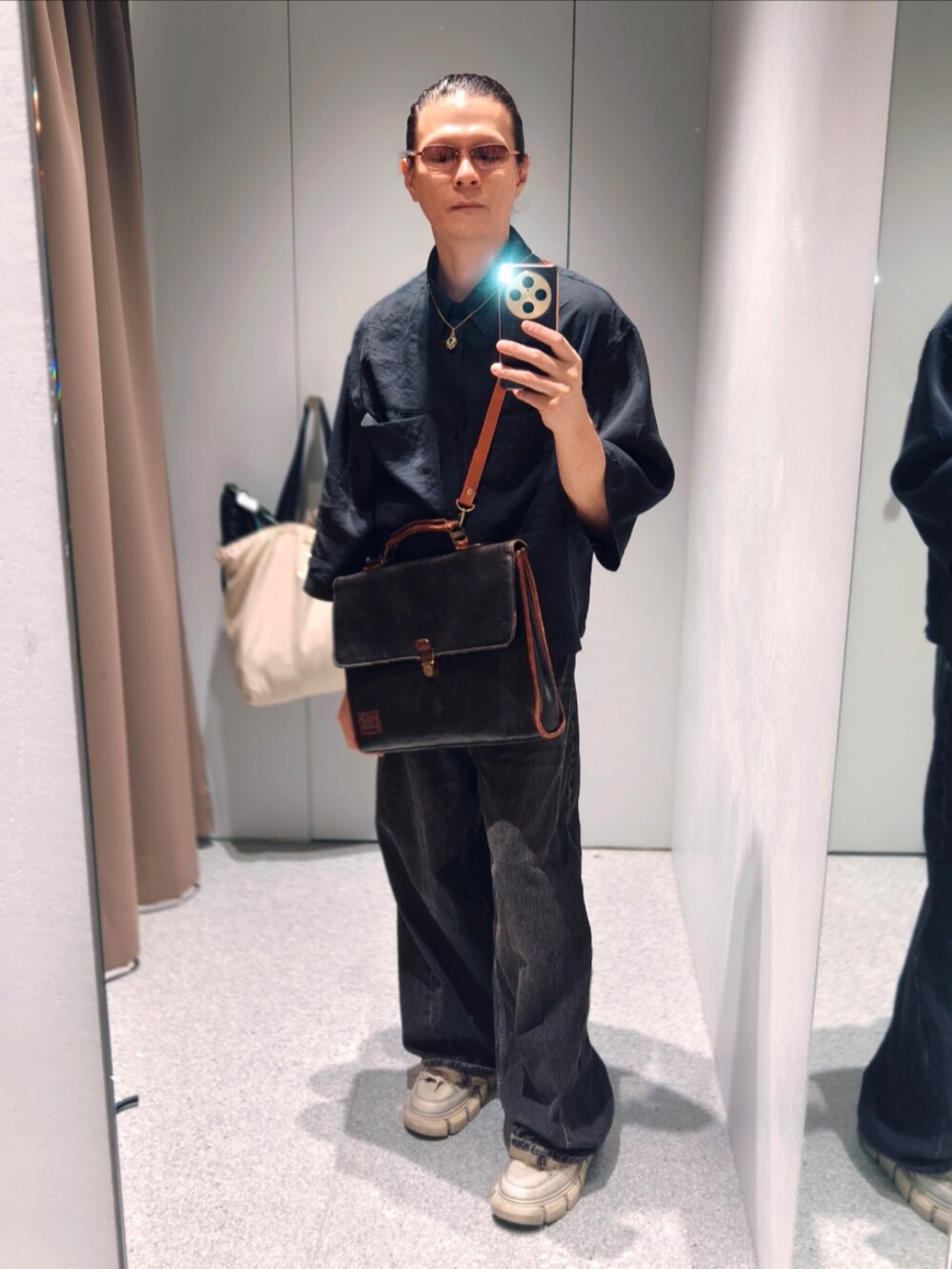 ブラック系のデニムパンツを着用したメンズの秋コーディネートの2枚目の写真