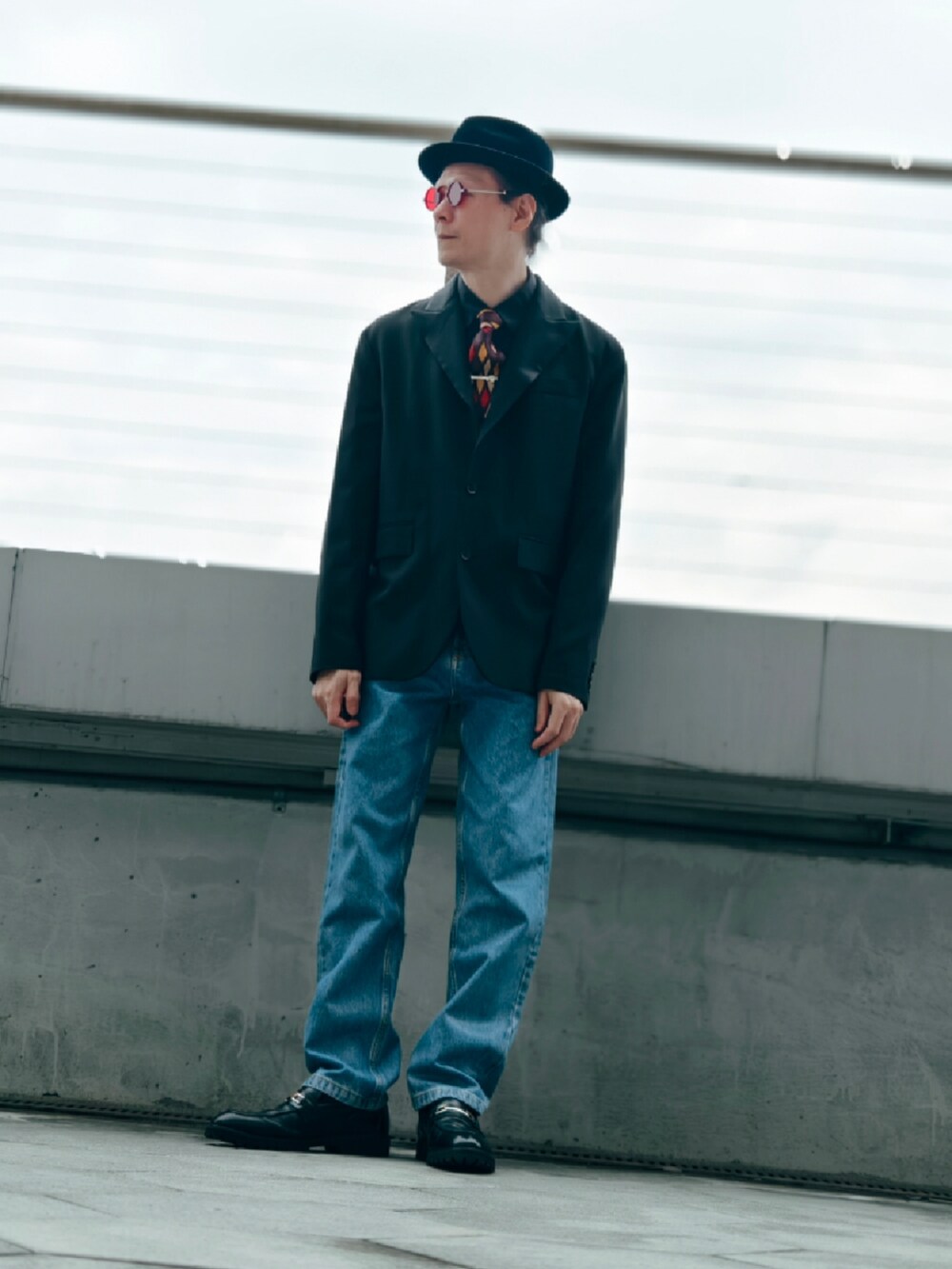 レッド系のメガネを着用したメンズの冬コーディネートの2枚目の写真