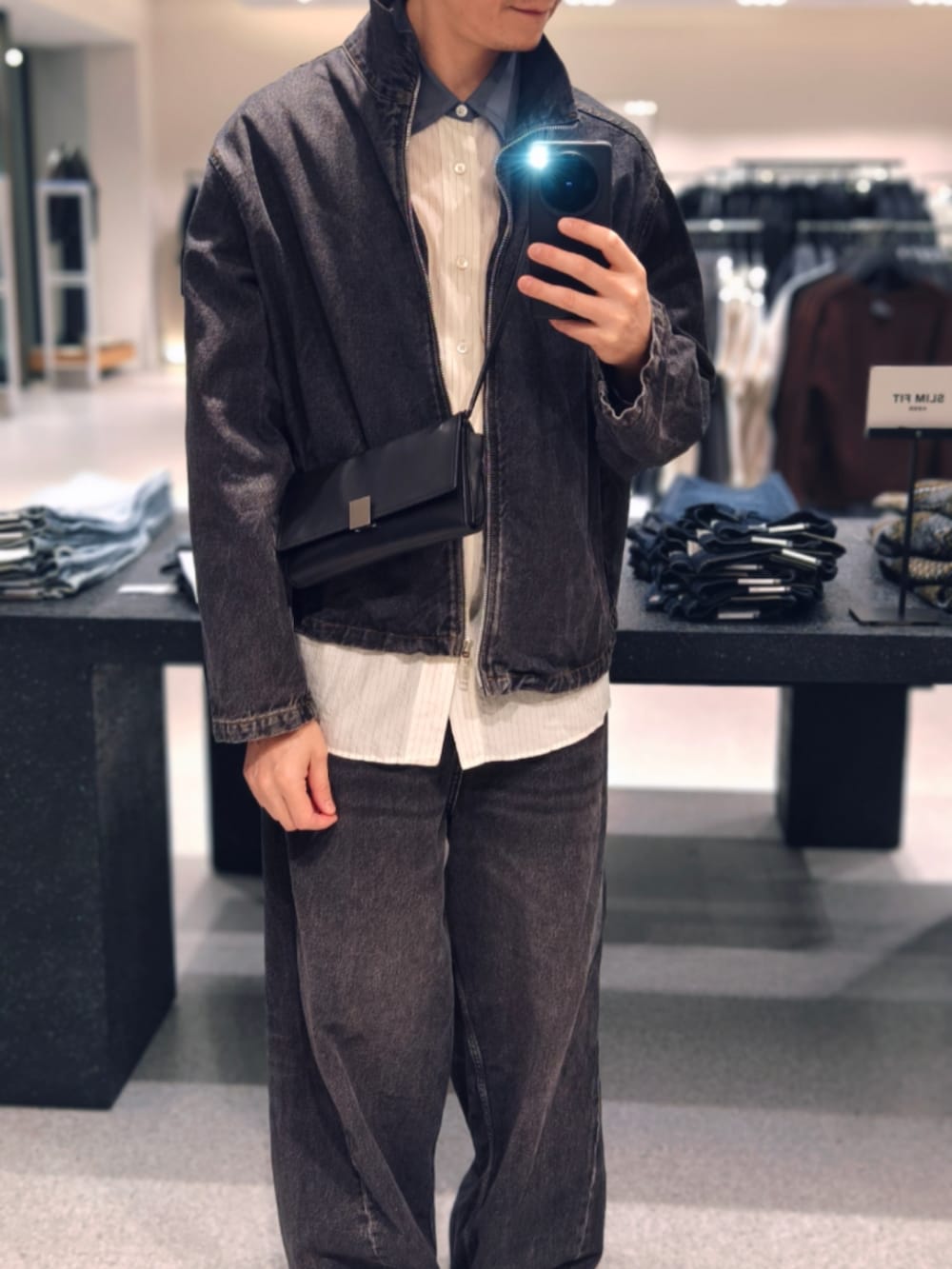 ブラック系のデニムジャケットを着用したメンズの秋コーディネートの5枚目の写真