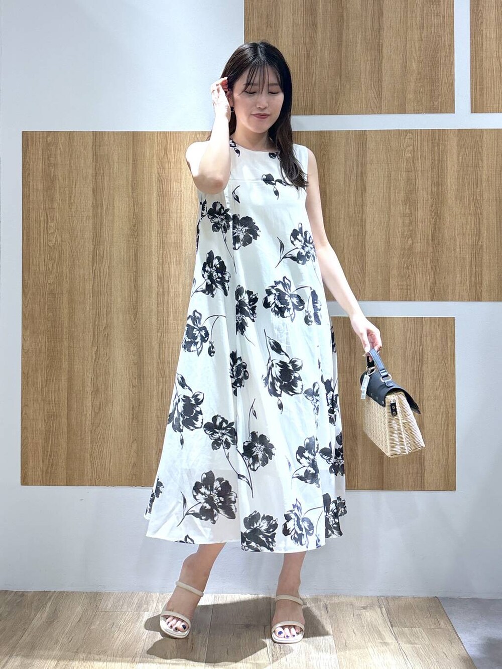 ブラック系のかごバッグ、ホワイト系のサンダル、ホワイト系のカーディガン/ボレロを着用したレディースの春コーディネートの4枚目の写真