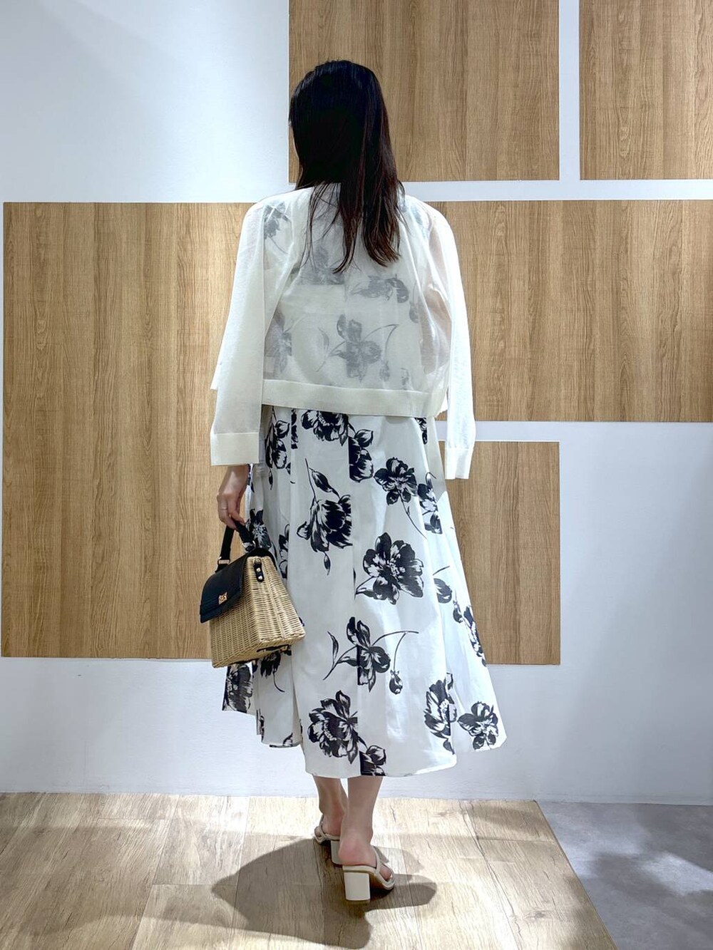 ブラック系のかごバッグ、ホワイト系のサンダル、ホワイト系のカーディガン/ボレロを着用したレディースの春コーディネートの3枚目の写真