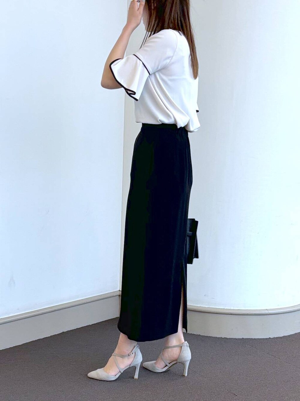 ブラック系のトートバッグ、グレー系のパンプス、ホワイト系のシャツ/ブラウスを着用したレディースの春コーディネートの3枚目の写真