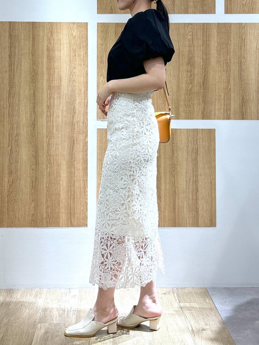 ホワイト系のスカート、イエロー系のハンドバッグ、ブラック系のシャツ/ブラウスを着用したレディースの春コーディネートの2枚目の写真