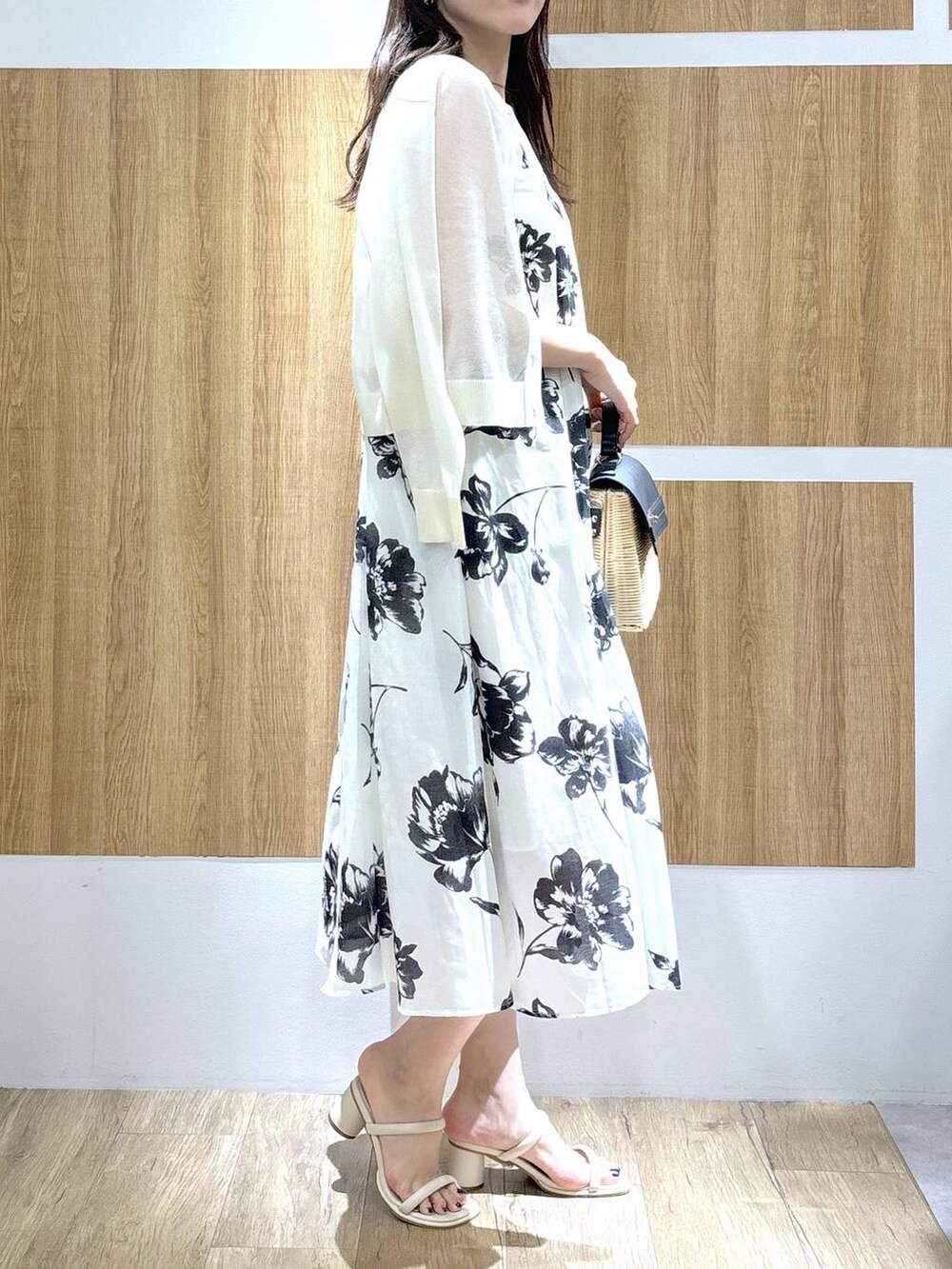 ブラック系のかごバッグ、ホワイト系のサンダル、ホワイト系のカーディガン/ボレロを着用したレディースの春コーディネートの2枚目の写真