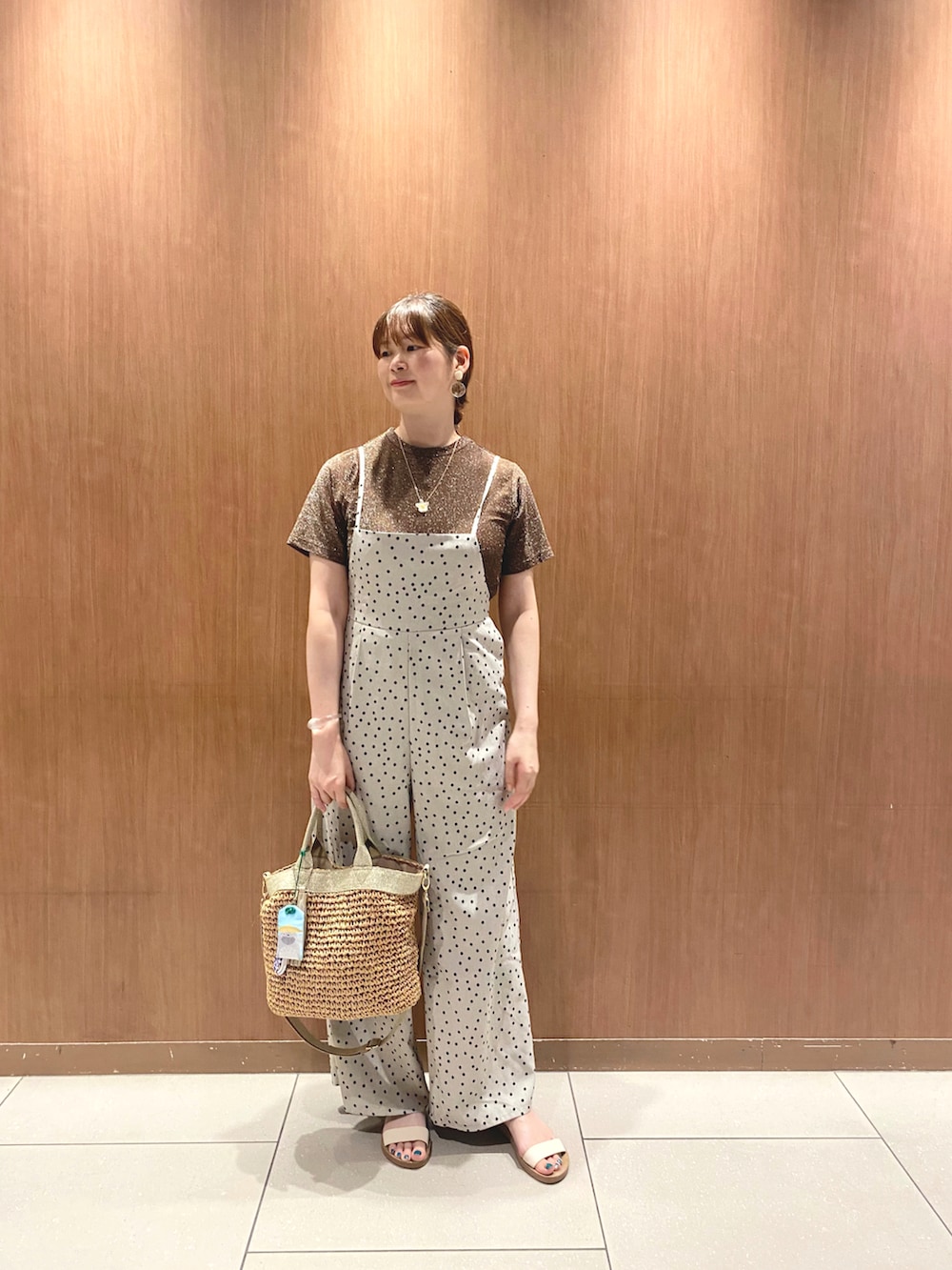 ブラウン系のTシャツ/カットソー、ベージュ系のサロペット/オーバーオール、ゴールド系のトートバッグを着用したレディースの夏コーディネートの2枚目の写真