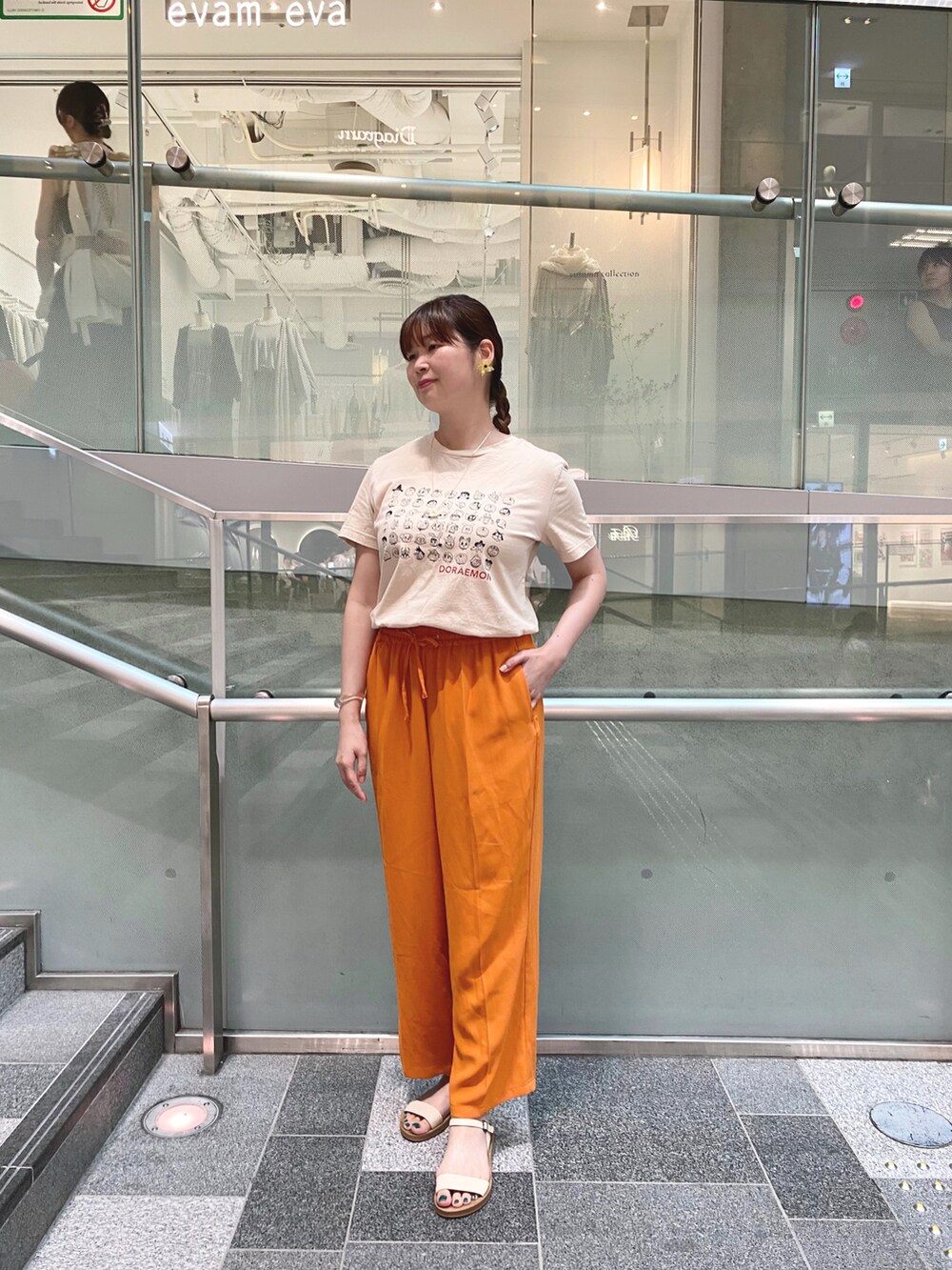 ベージュ系のTシャツ/カットソー、オレンジ系のその他パンツ、ホワイト系のサンダルを着用したレディースの夏コーディネートの2枚目の写真