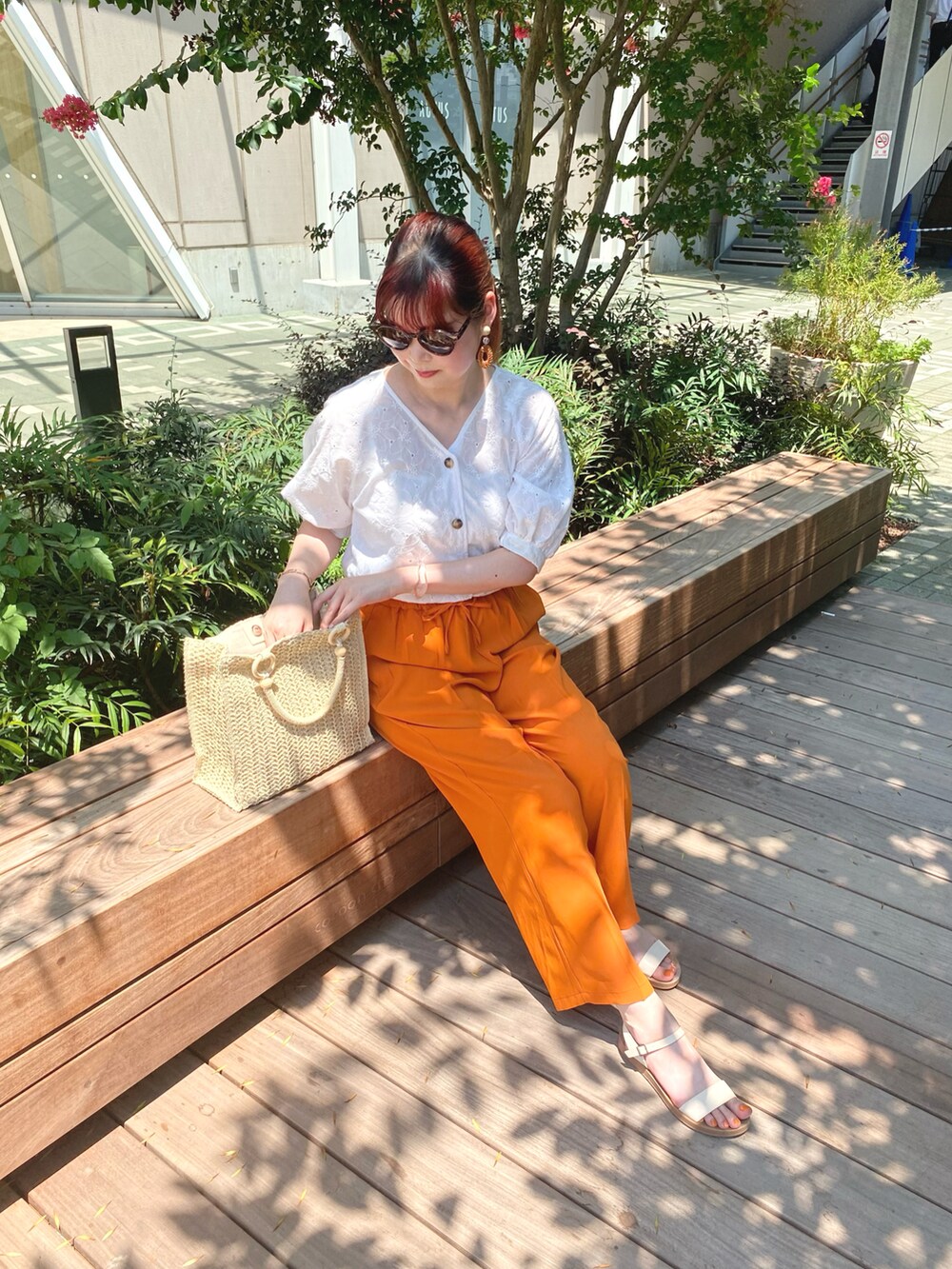 オレンジ系のその他パンツ、ホワイト系のサンダル、ホワイト系のシャツ/ブラウスを着用したレディースの夏コーディネートの3枚目の写真