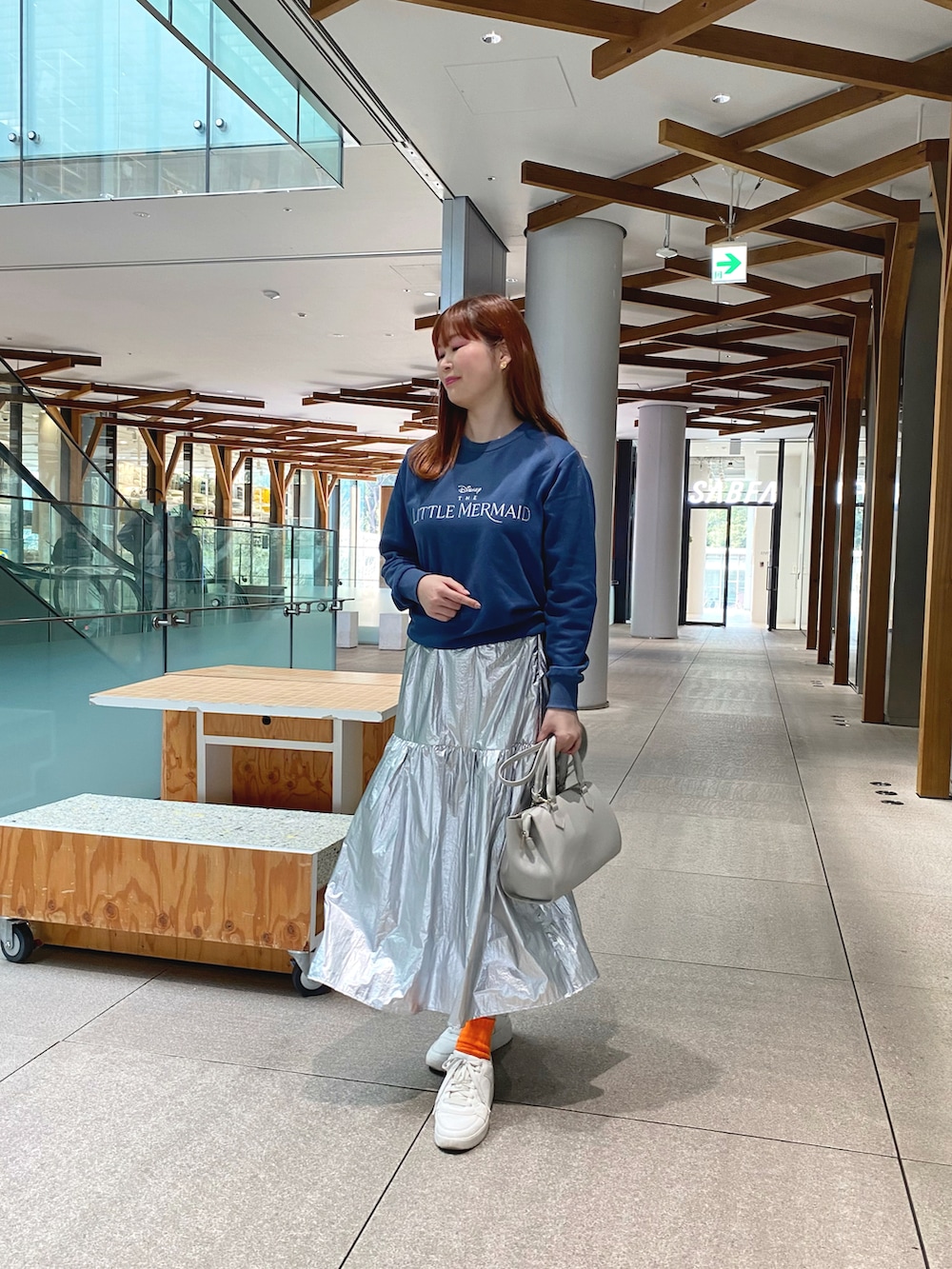 ブルー系のスウェット、シルバー系のスカート、グレー系のショルダーバッグを着用したレディースの冬コーディネートの3枚目の写真