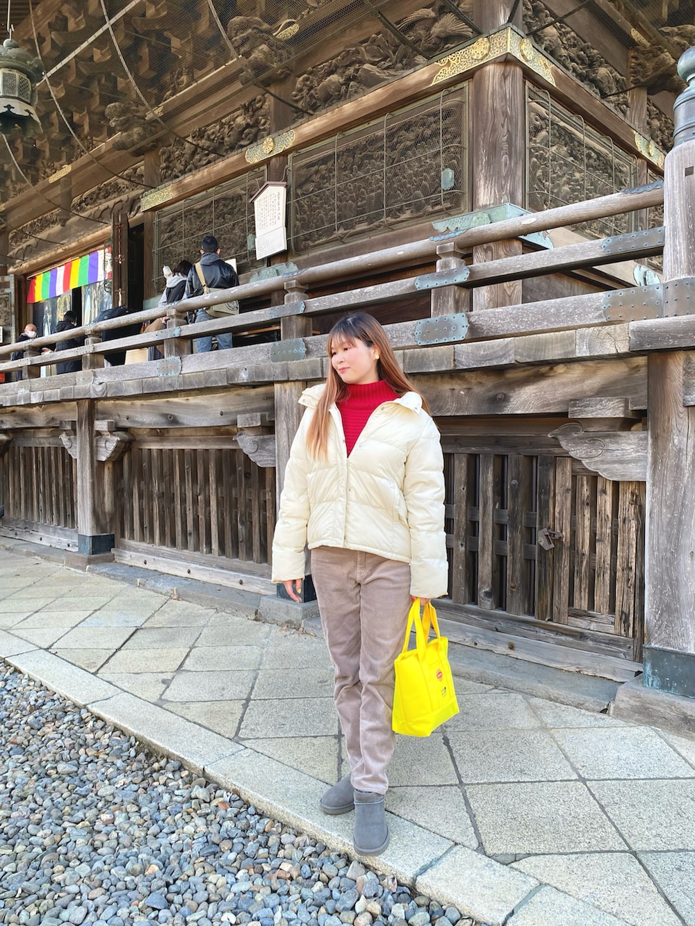 ホワイト系のダウンジャケット/コート、レッド系のニット/セーター、グレー系のその他パンツを着用したレディースの冬コーディネートの2枚目の写真