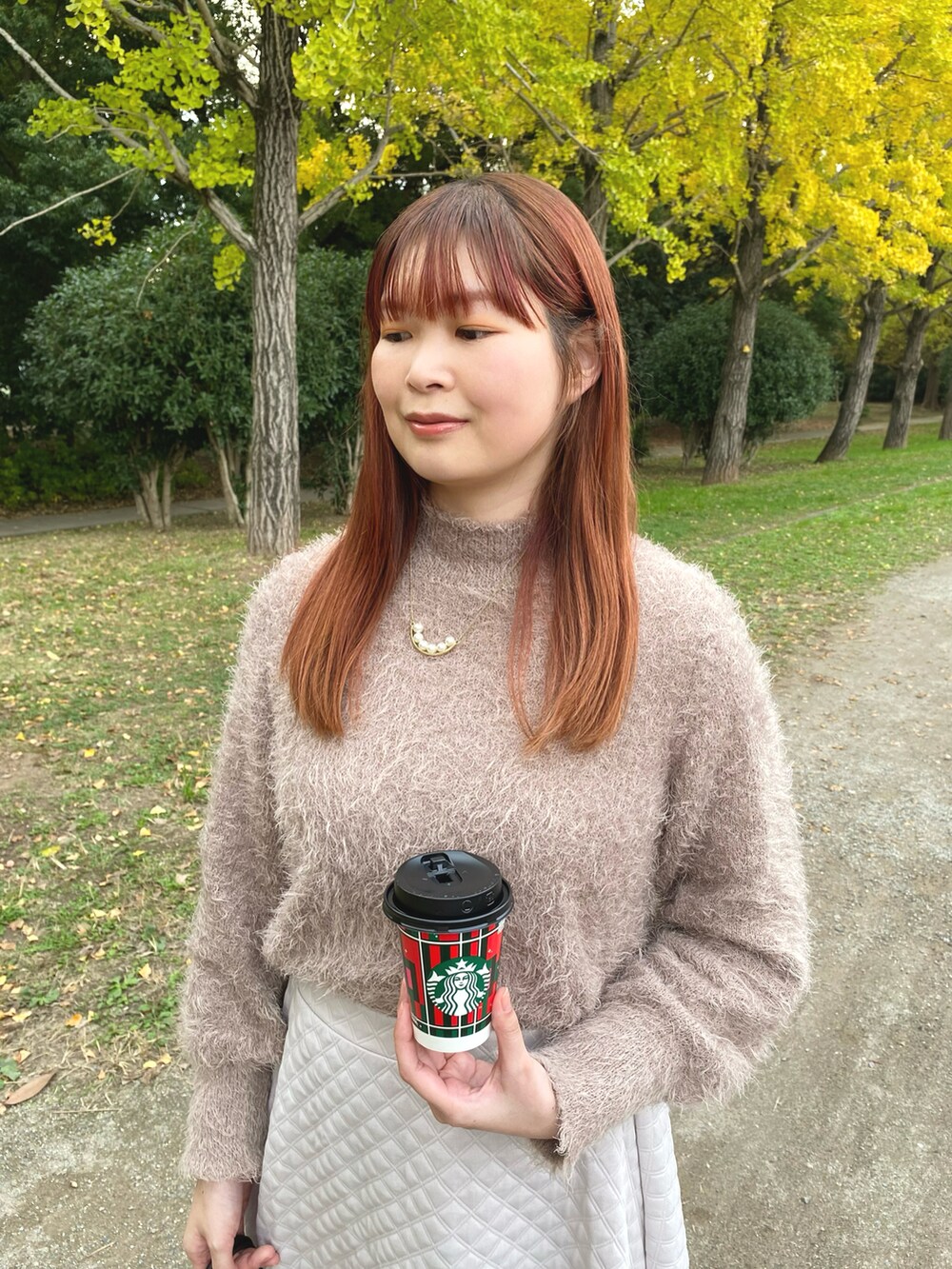 ホワイト系のスカート、ブラウン系のローファー、ブラウン系のニット/セーターを着用したレディースの秋コーディネートの3枚目の写真