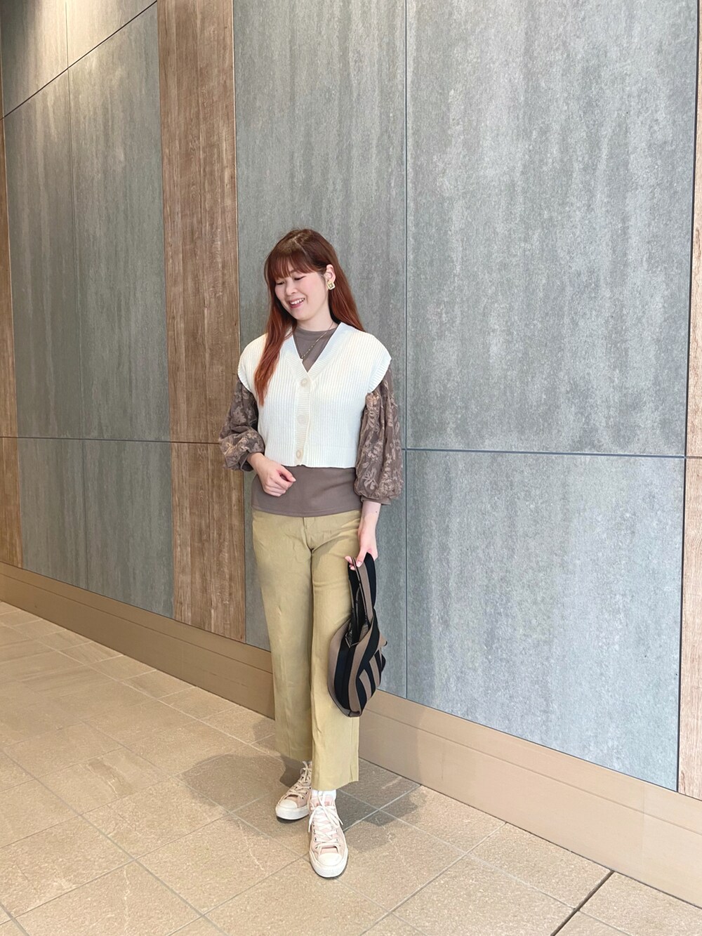 ブラウン系のシャツ/ブラウス、ホワイト系のベスト、イエロー系のその他パンツを着用したレディースの秋コーディネートの2枚目の写真