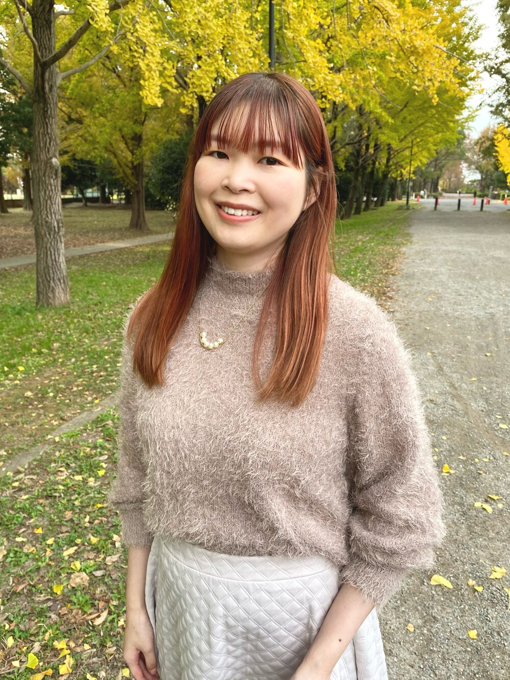 ホワイト系のスカート、ブラウン系のローファー、ブラウン系のニット/セーターを着用したレディースの秋コーディネートの4枚目の写真